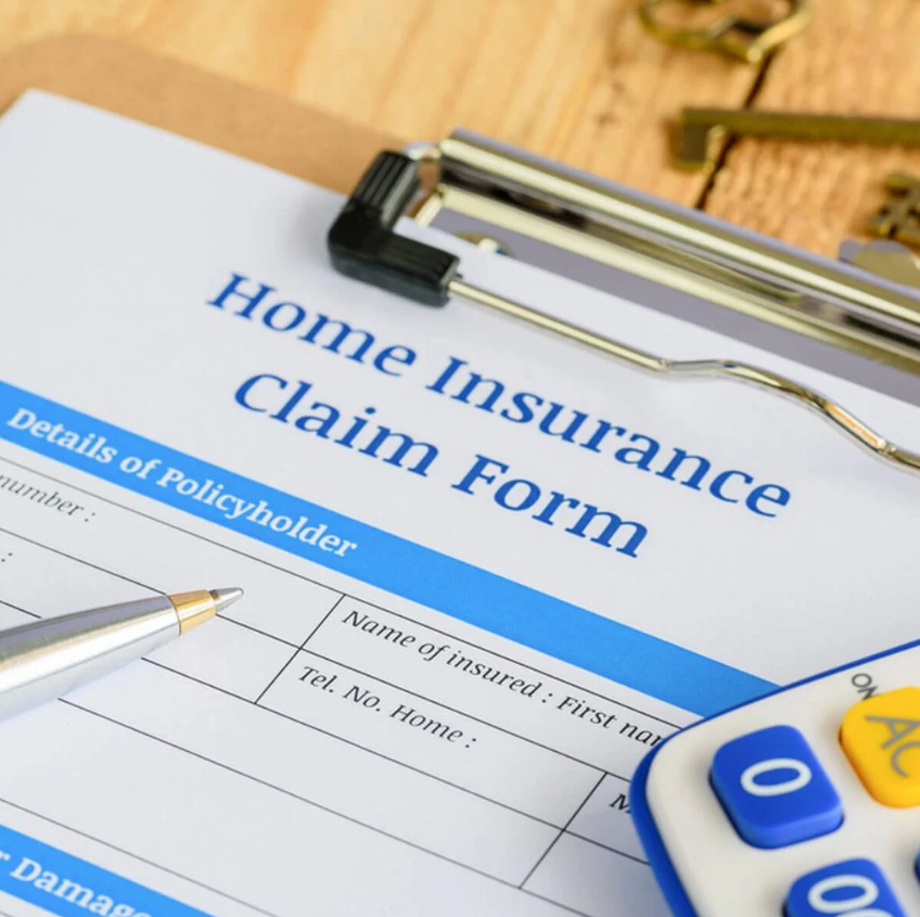 A home insurance claim form with a pen and calculator
