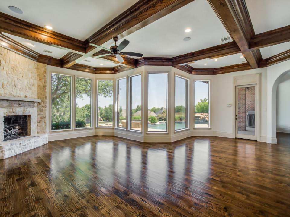 An empty living room with hardwood floors and a fireplace