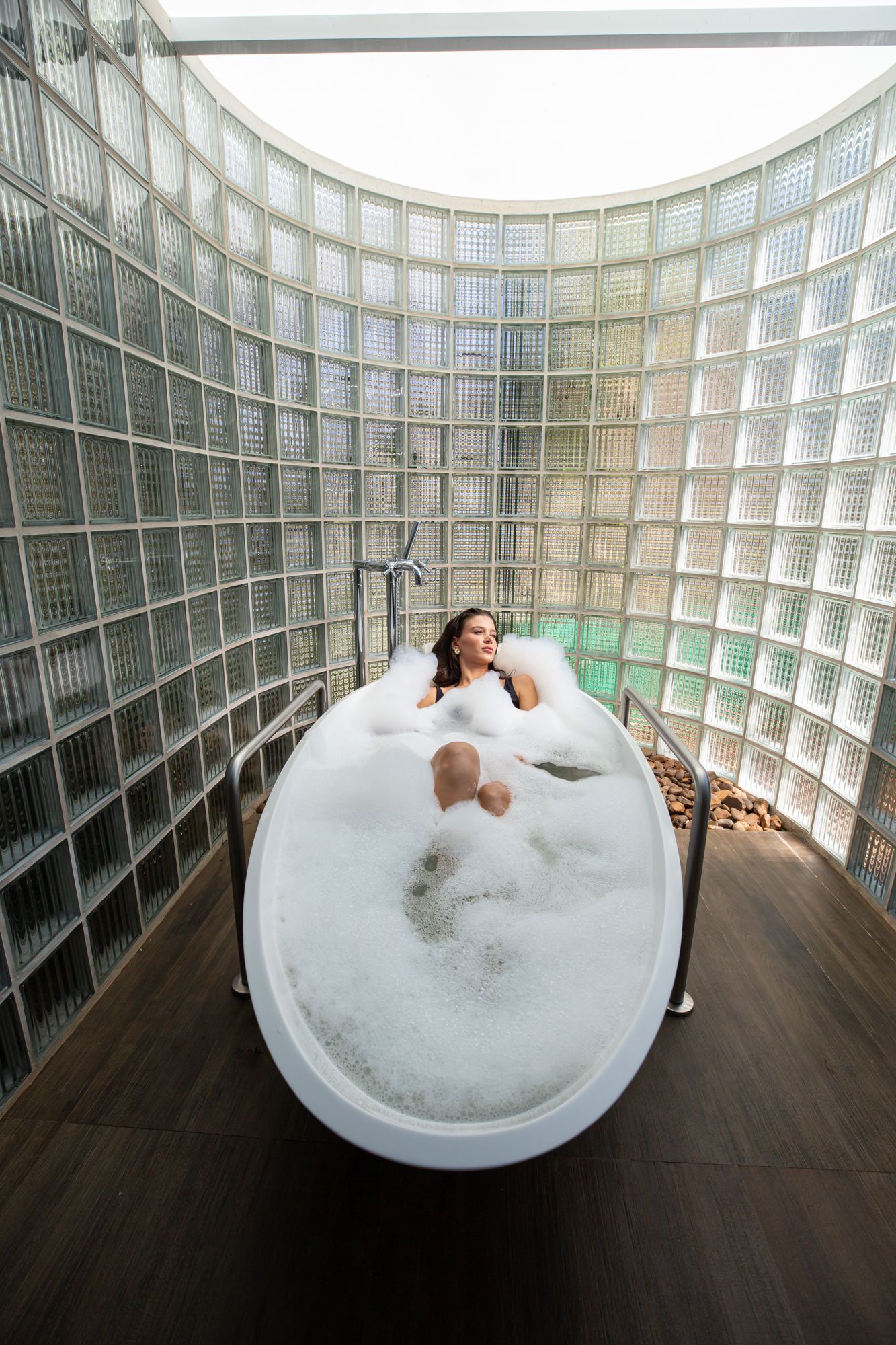 Sala de spa com mesa de massagem, roupão e assentos ao ar livre.