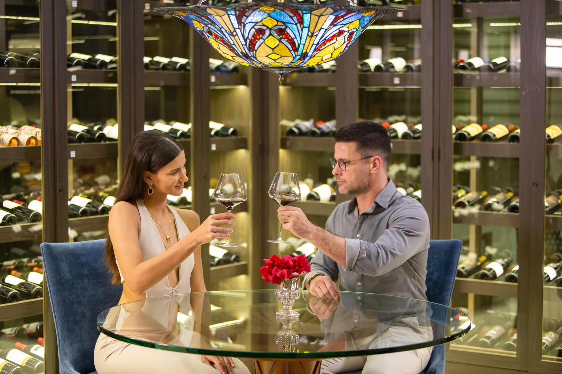Piscina em um resort tropical com espreguiçadeiras, palmeiras e prédios sob um céu azul.