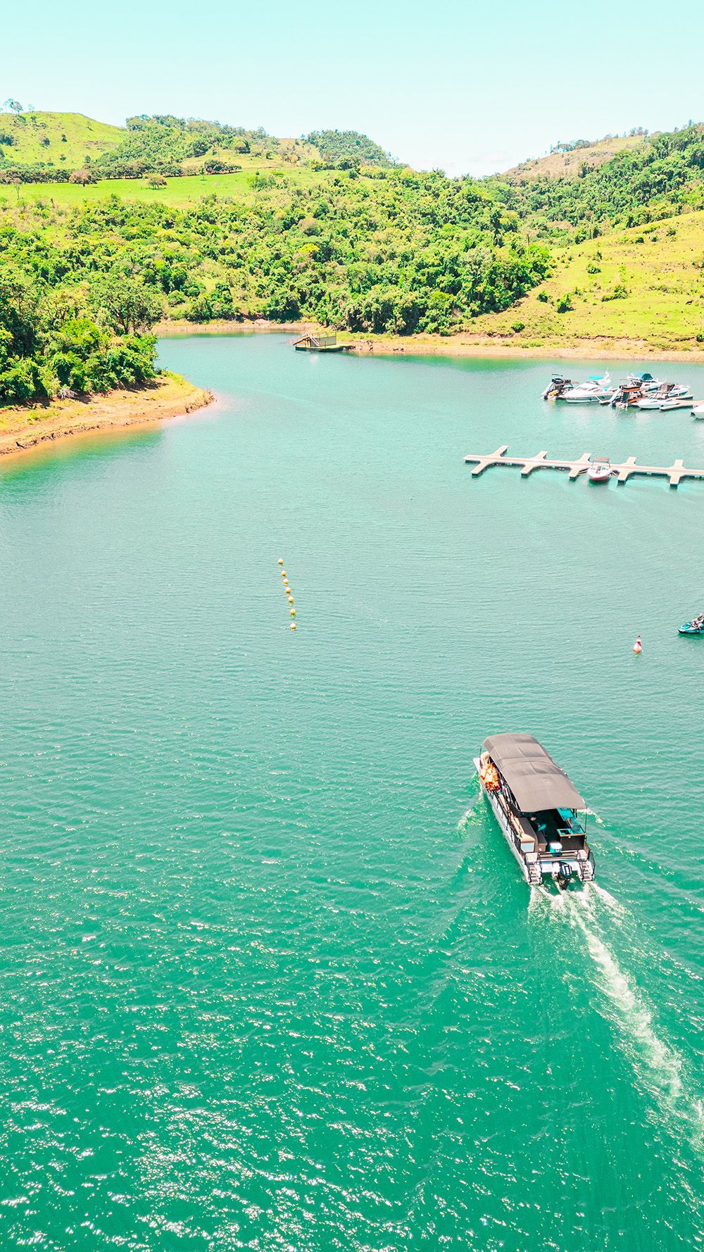 Homem em um jet ski azul, acelerando na água, causando um grande impacto.