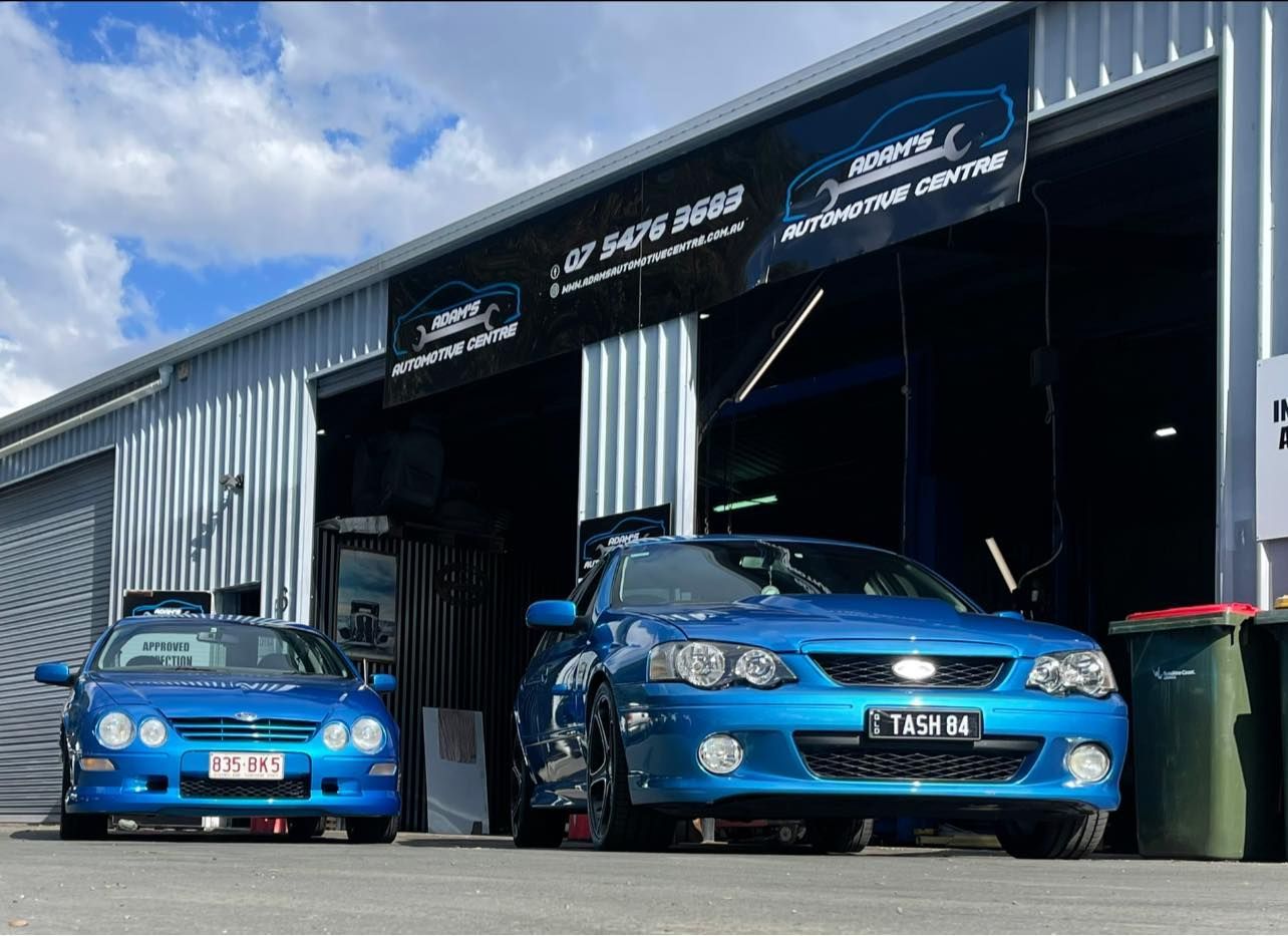 Two blue Ford cars parked outside an auto repair shop. — Adam's Automotive Centre in Nambour, QLD