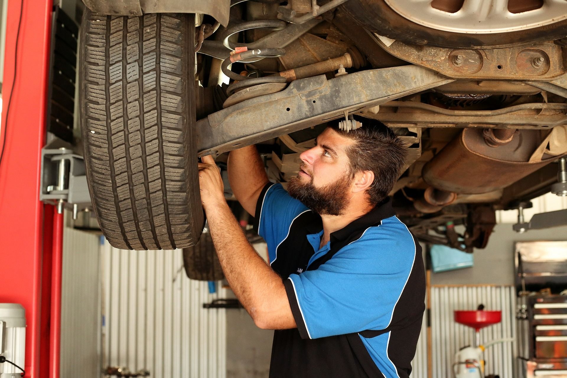 Mechanic Working on a Car Raised on a Lift in a Garage — Adam's Automotive Centre in Nambour, QLD