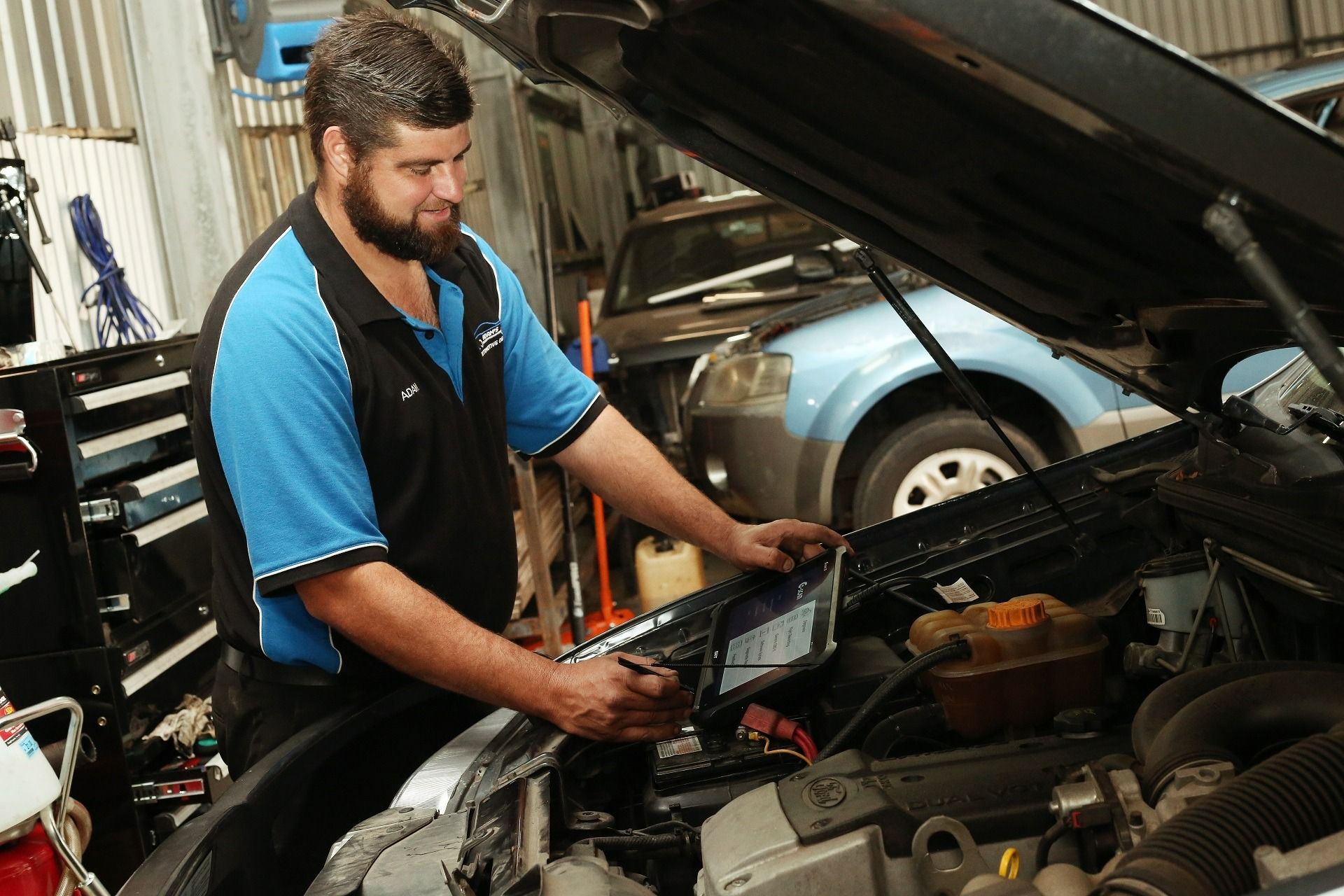Mechanic Using a Laptop to Diagnose a Car Engine in a Garage — Adam's Automotive Centre in Nambour, QLD