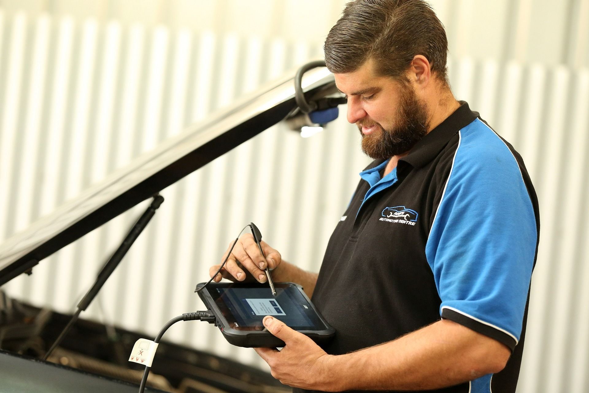 Mechanic Using a Tablet to Diagnose a Car Issue in a Garage — Adam's Automotive Centre in Nambour, QLD