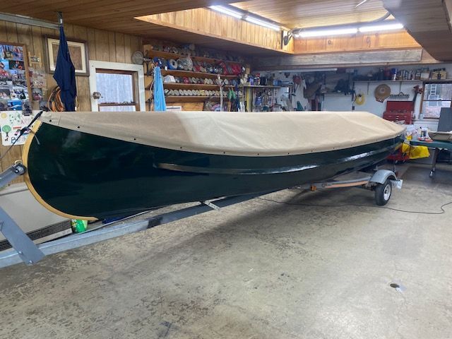 A dark green canoe with a beige Custom Canoe Covers