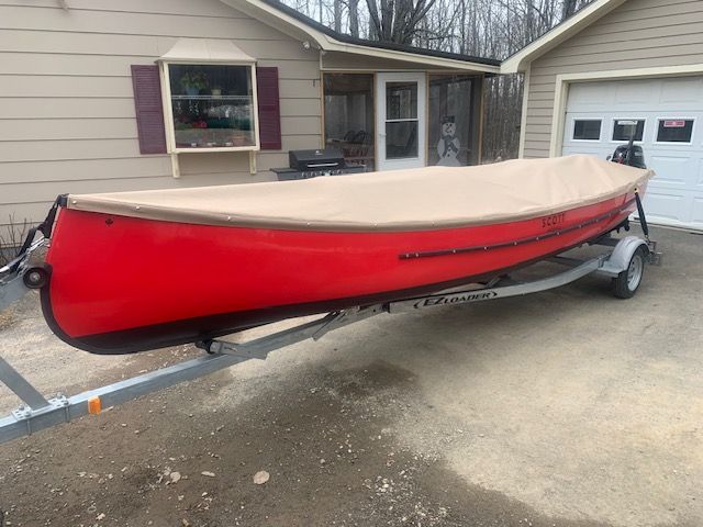 A man and a boy are looking at a map in a kitchen.