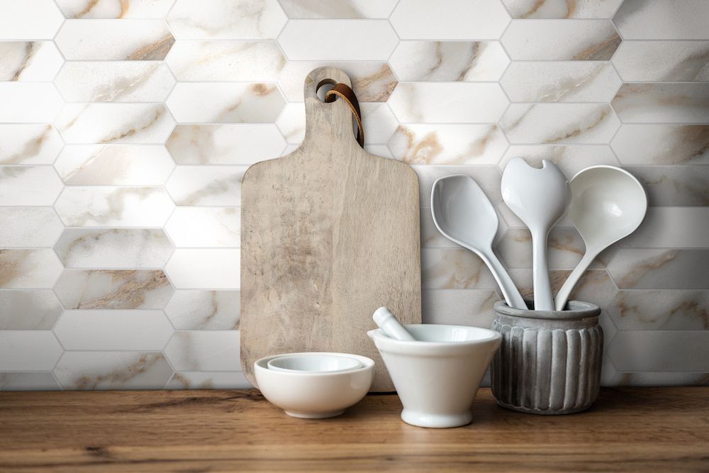A Wooden Cutting Board, Bowls, Spoons and Mortar and Pestle on a Wooden Counter — Tileflair in Mitchell, ACT