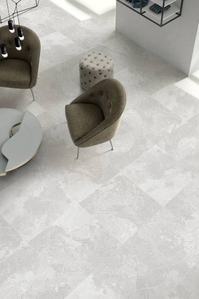 A Living Room With a Couch, Chairs and Ottomans on a Tiled Floor — Tileflair in Mitchell, ACT