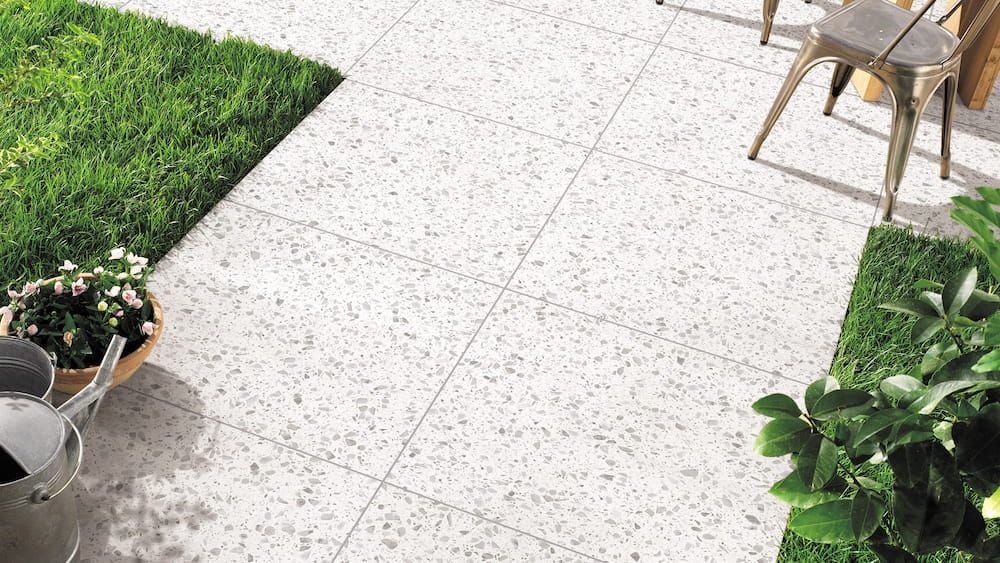 There is a Wheelbarrow With Flowers in It on the Sidewalk — Tileflair in Mitchell, ACT