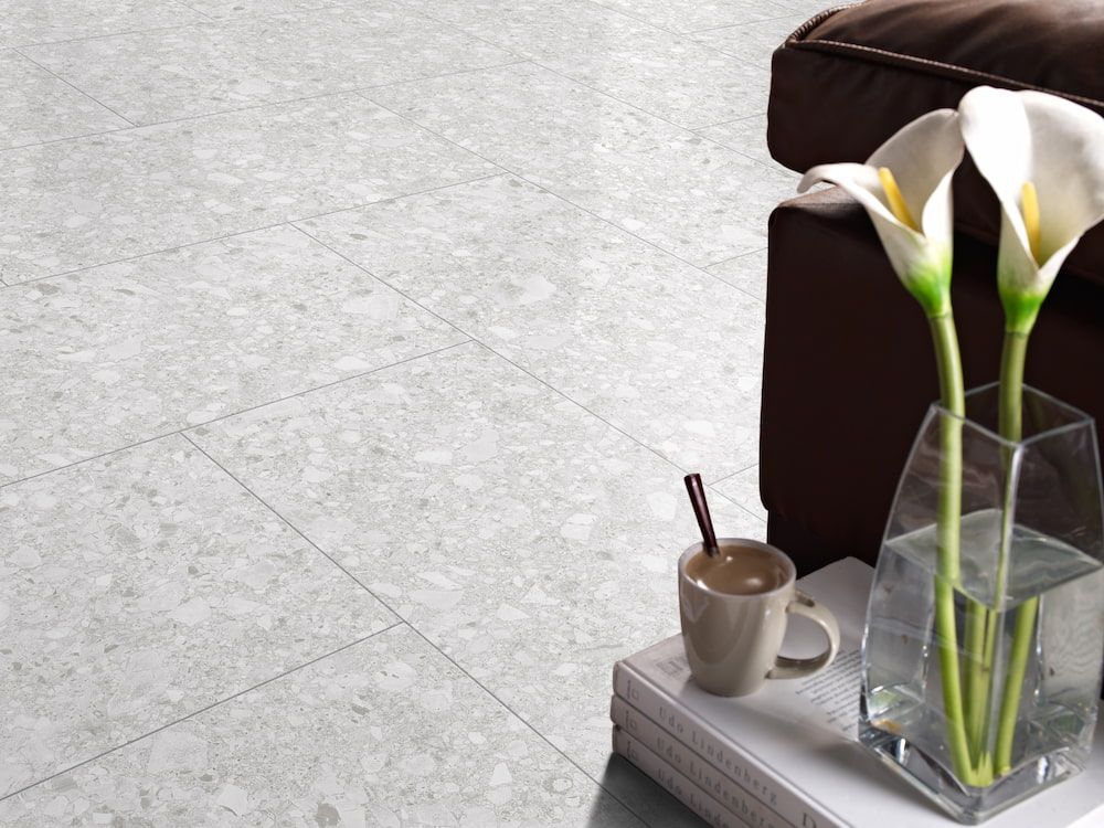 A Vase of Flowers Sits on a Table Next to a Cup of Coffee — Tileflair in Mitchell, ACT
