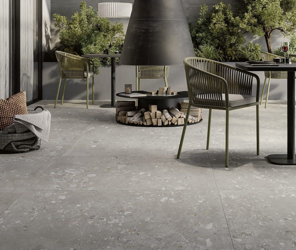 A Patio With Tables and Chairs and a Fireplace — Tileflair in Mitchell, ACT