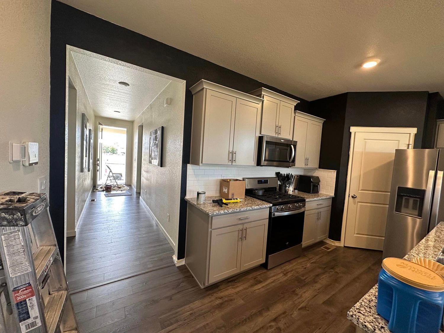 A kitchen with white cabinets and black walls is being remodeled.
