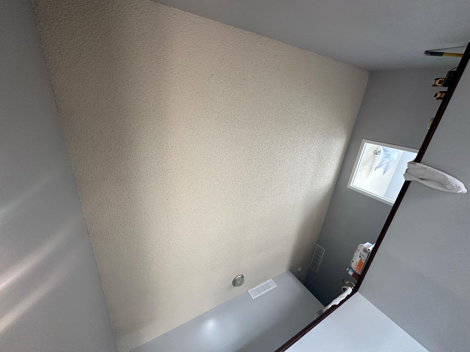 A bathroom with a large mirror and a window.