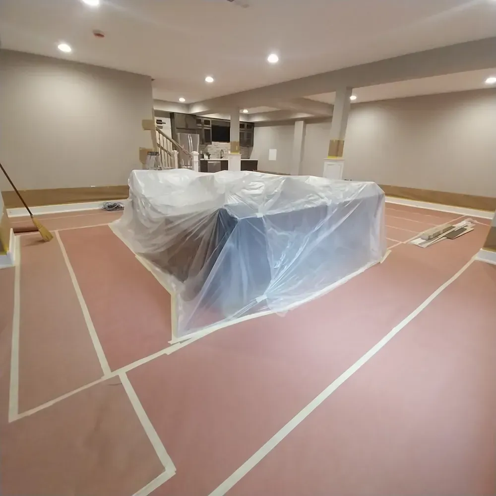 A couch is wrapped in plastic in a basement