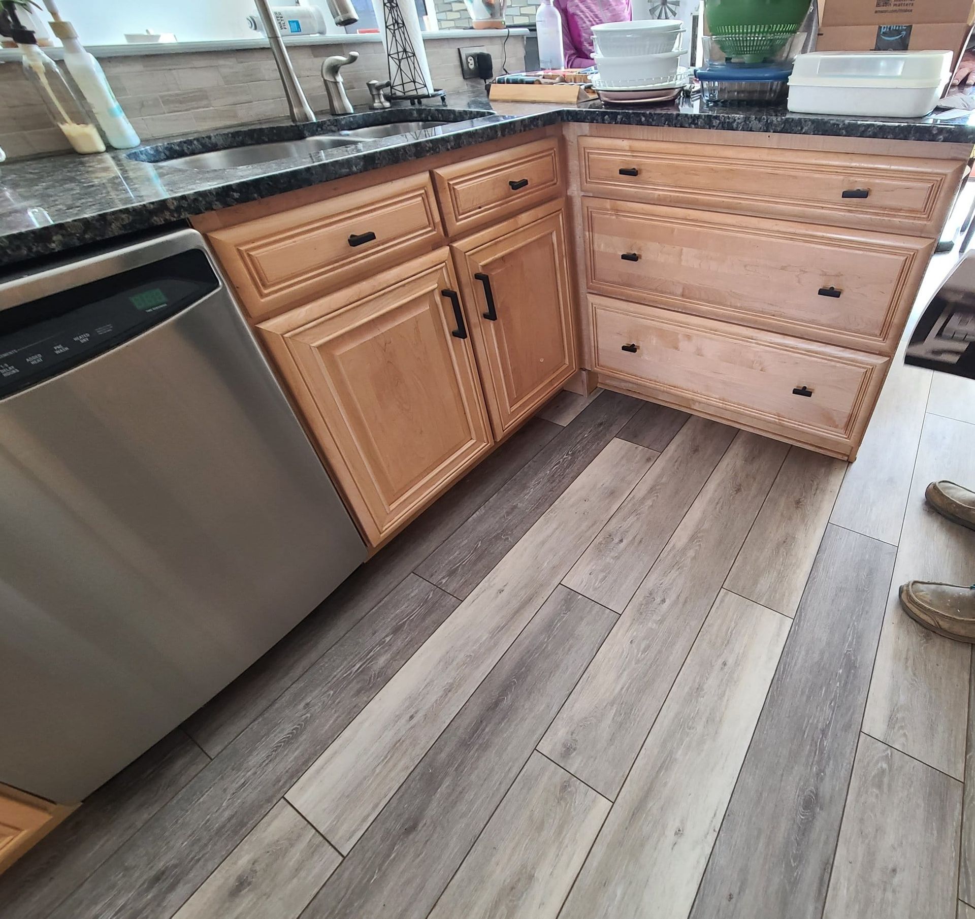 A kitchen with wooden cabinets and a stainless steel dishwasher.