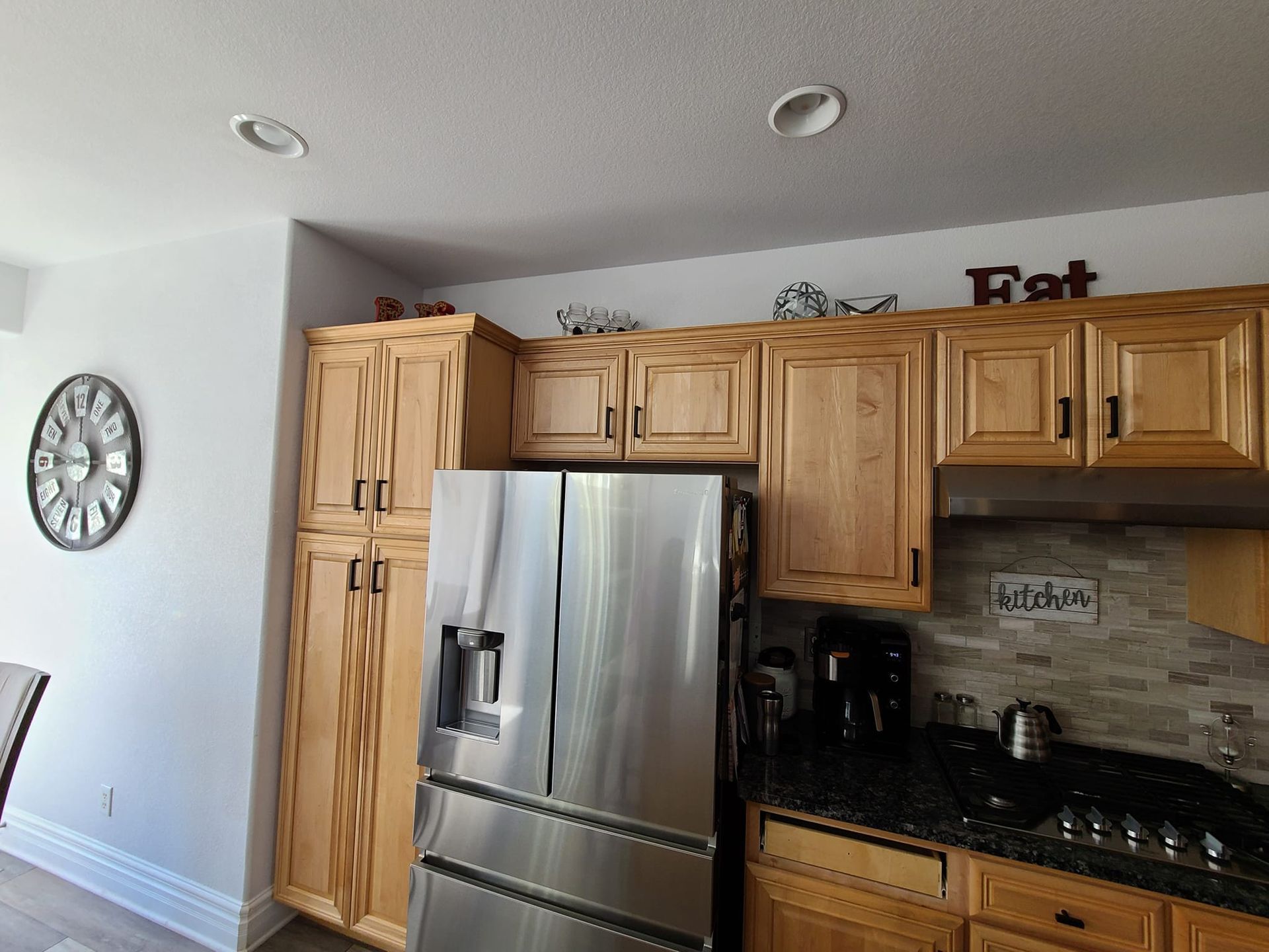 A kitchen with stainless steel appliances and wooden cabinets.