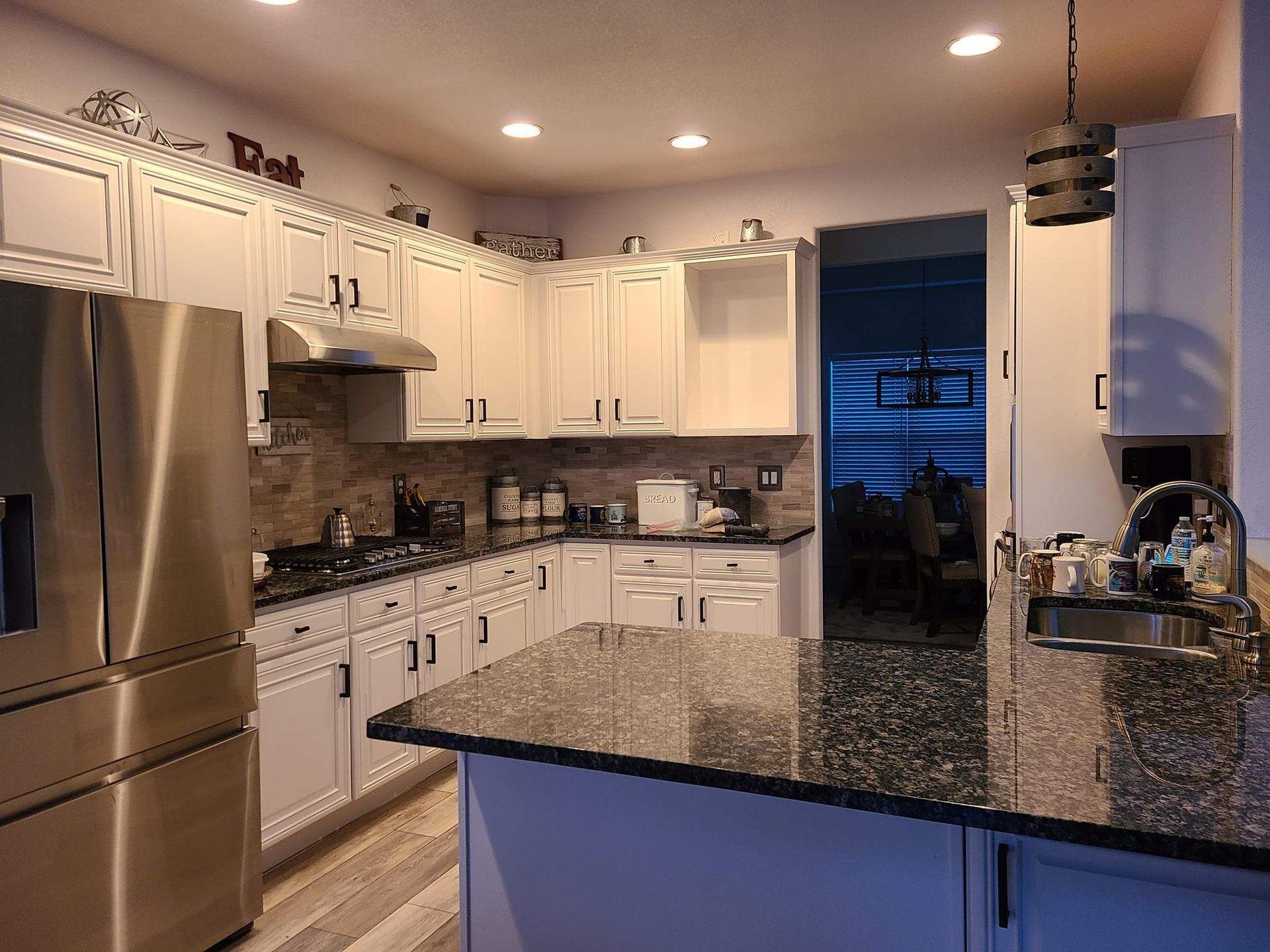 A kitchen with white cabinets and stainless steel appliances
