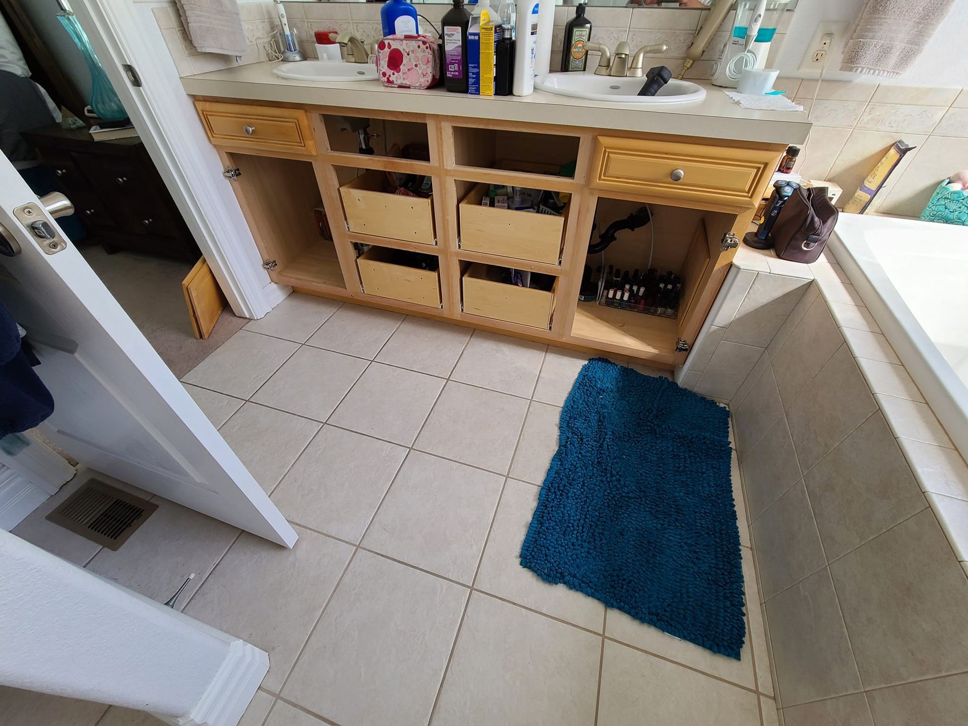 A bathroom with two sinks and a blue rug on the floor