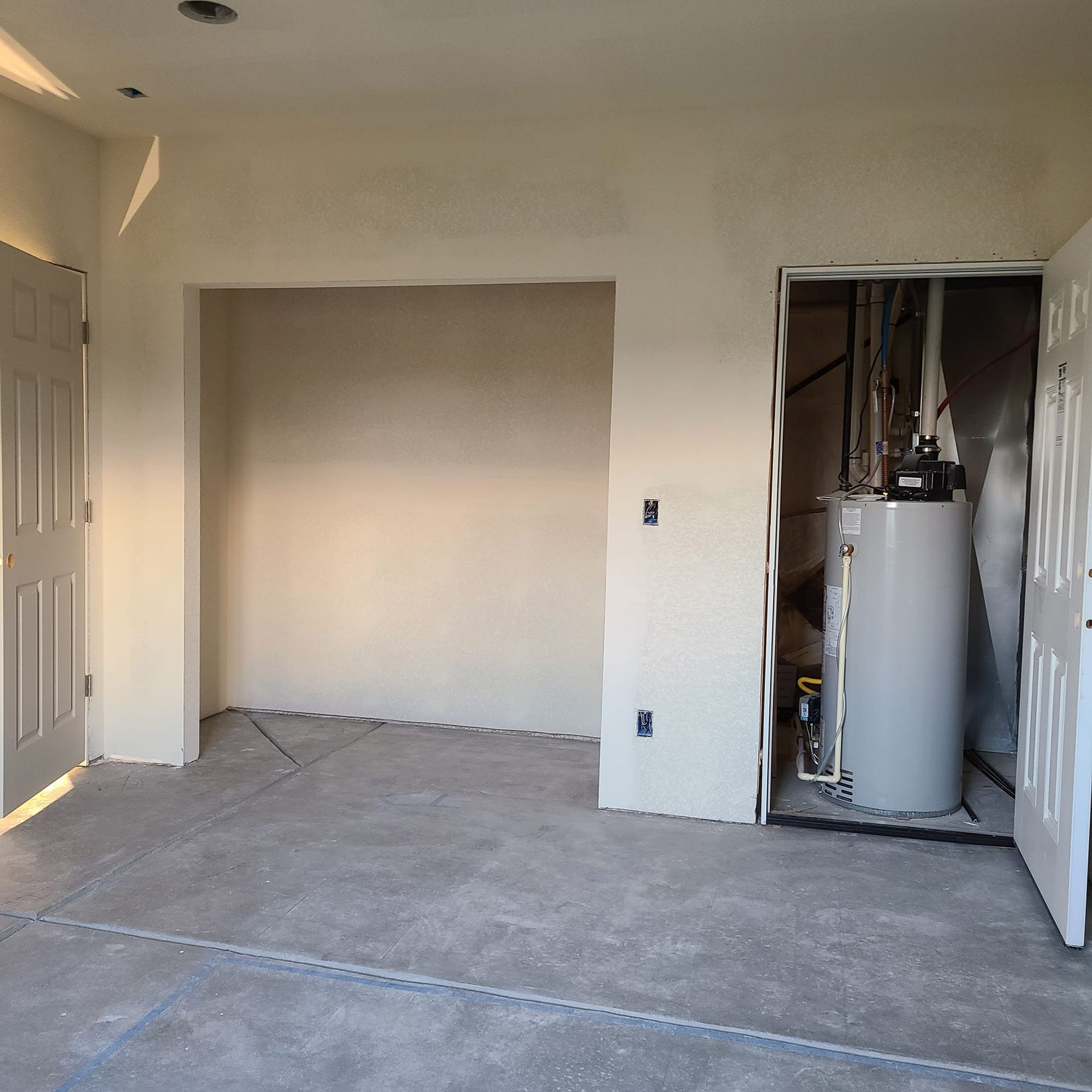 An empty room with a water heater in it