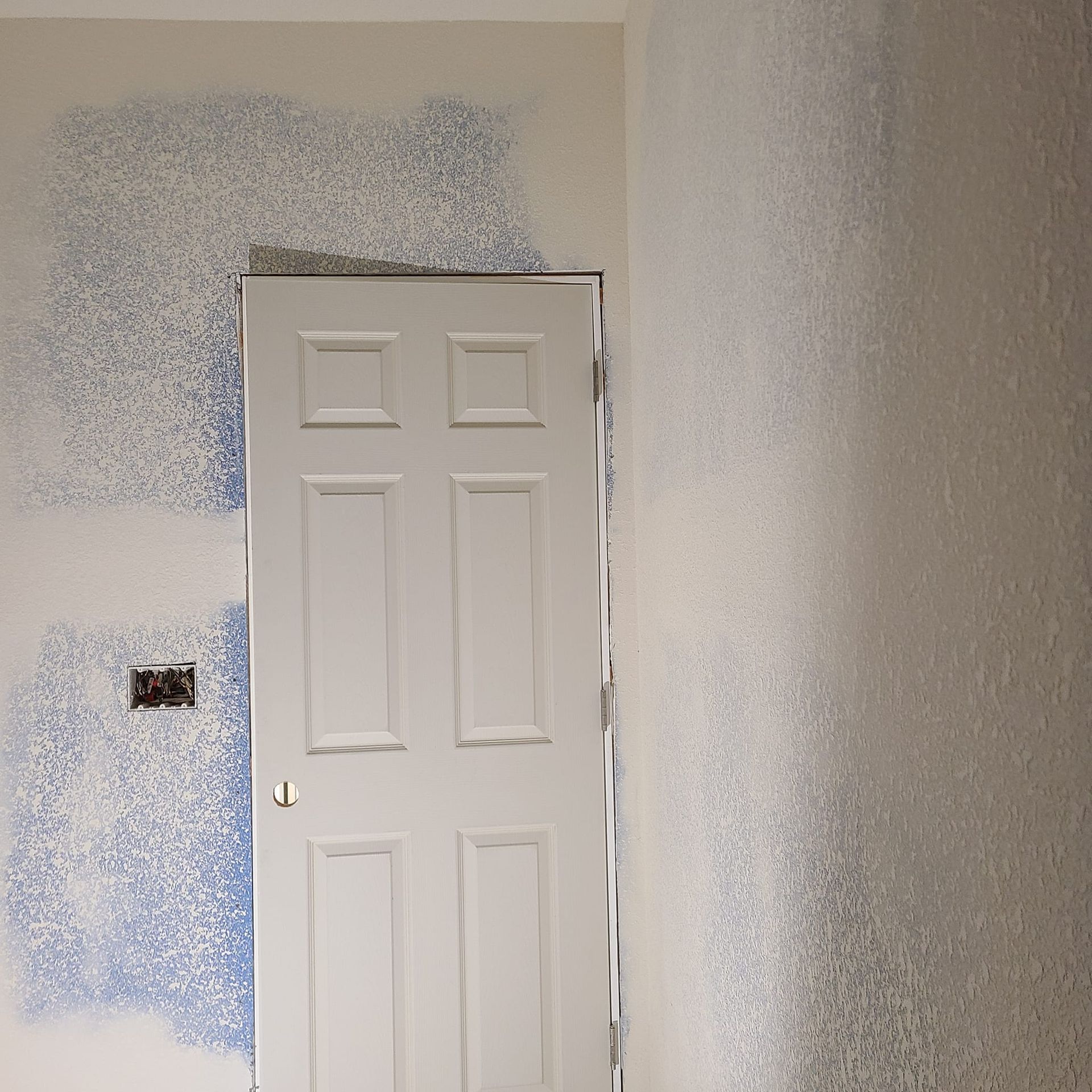A white door in a room with blue paint on the wall