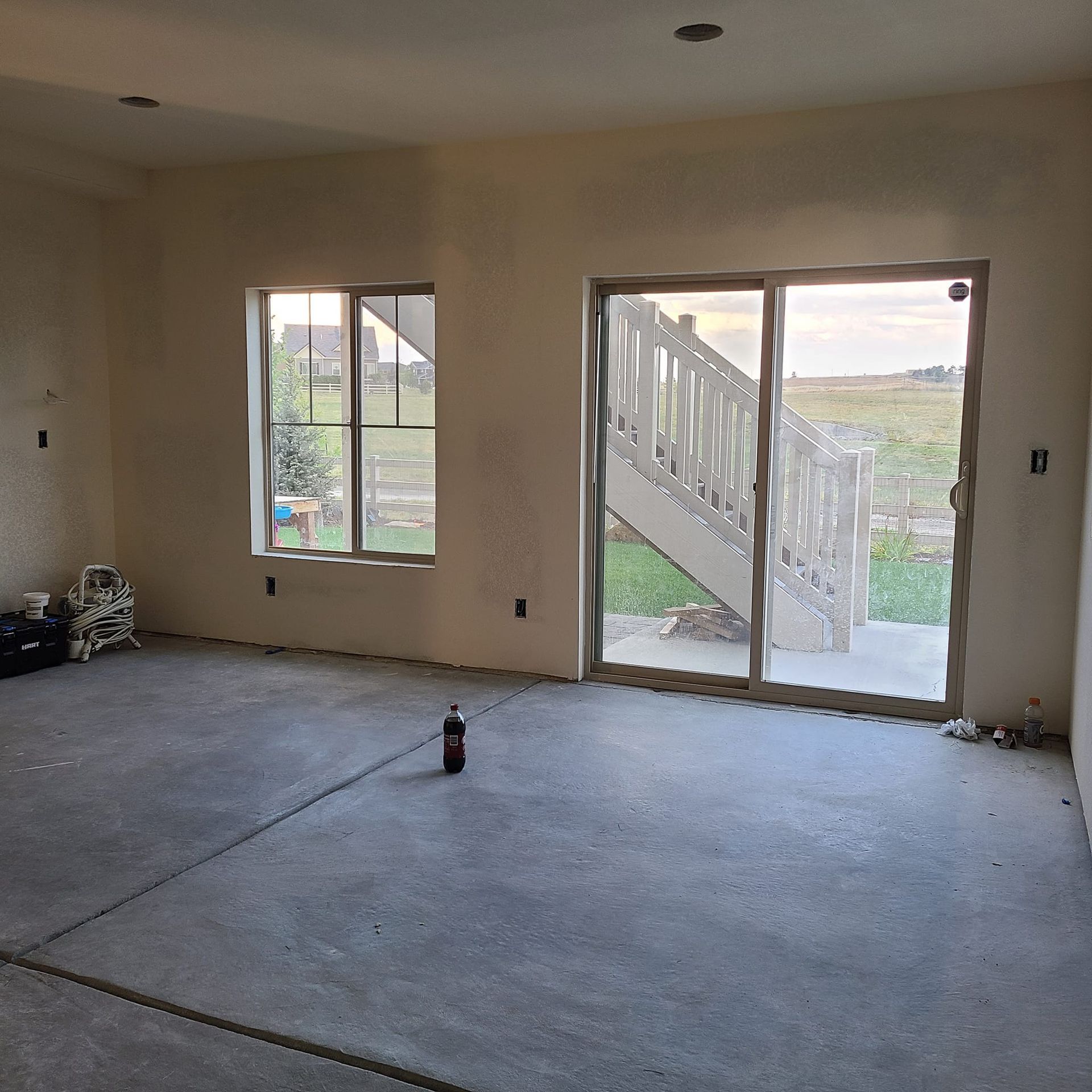 An empty room with a sliding glass door and two windows