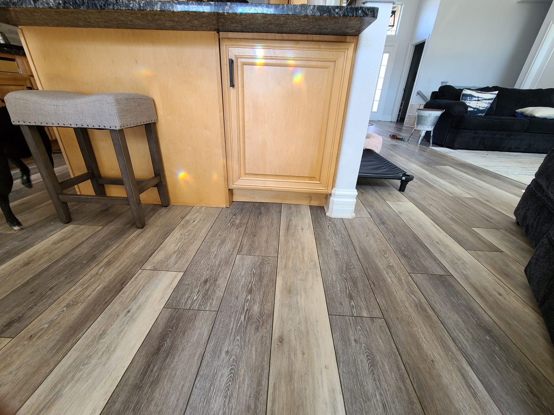 A kitchen with a wooden floor and stools.