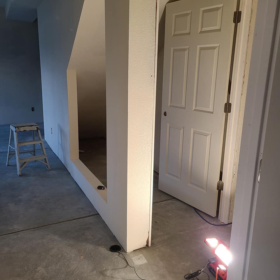 A room with a door and a ladder in it