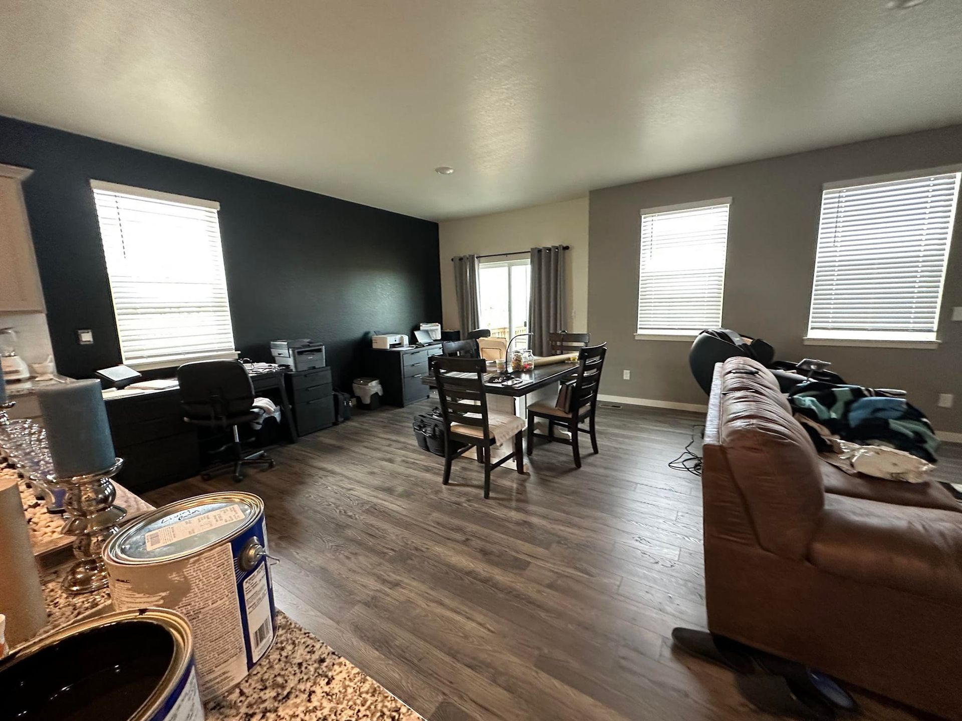 A living room with hardwood floors , a couch , a table and chairs.