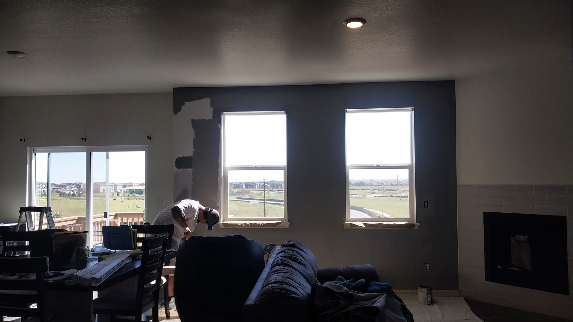 A living room with a couch and three windows