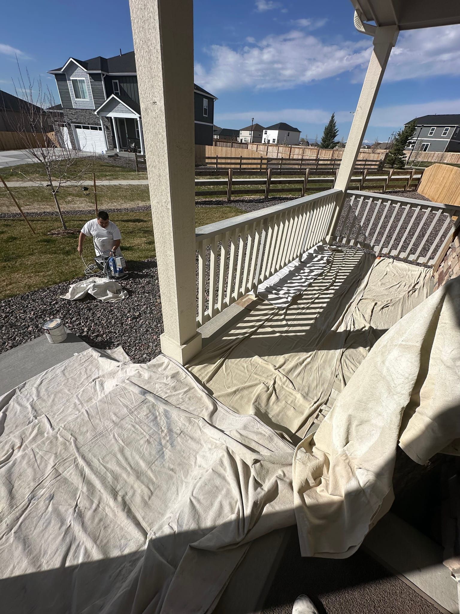 A child is playing on a porch with a white tarp on it.
