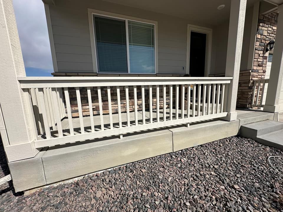 A porch with a white railing and a sliding glass door.