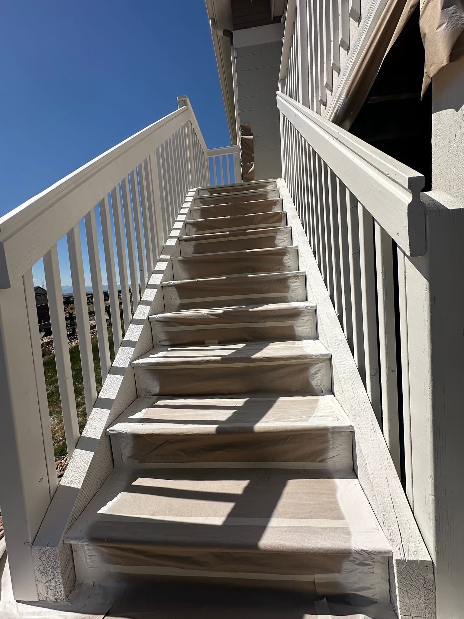 A set of stairs leading up to a balcony with a white railing