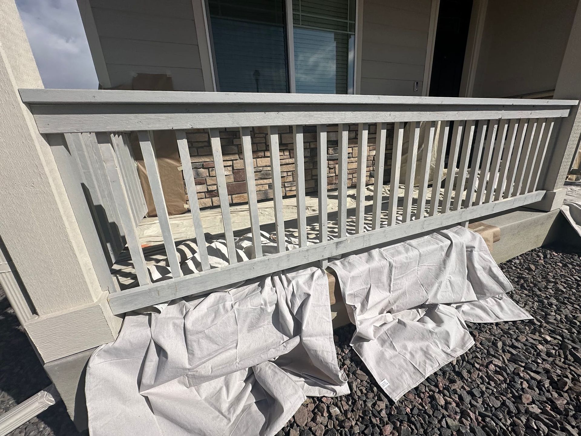 A white railing is sitting on top of a pile of gravel.