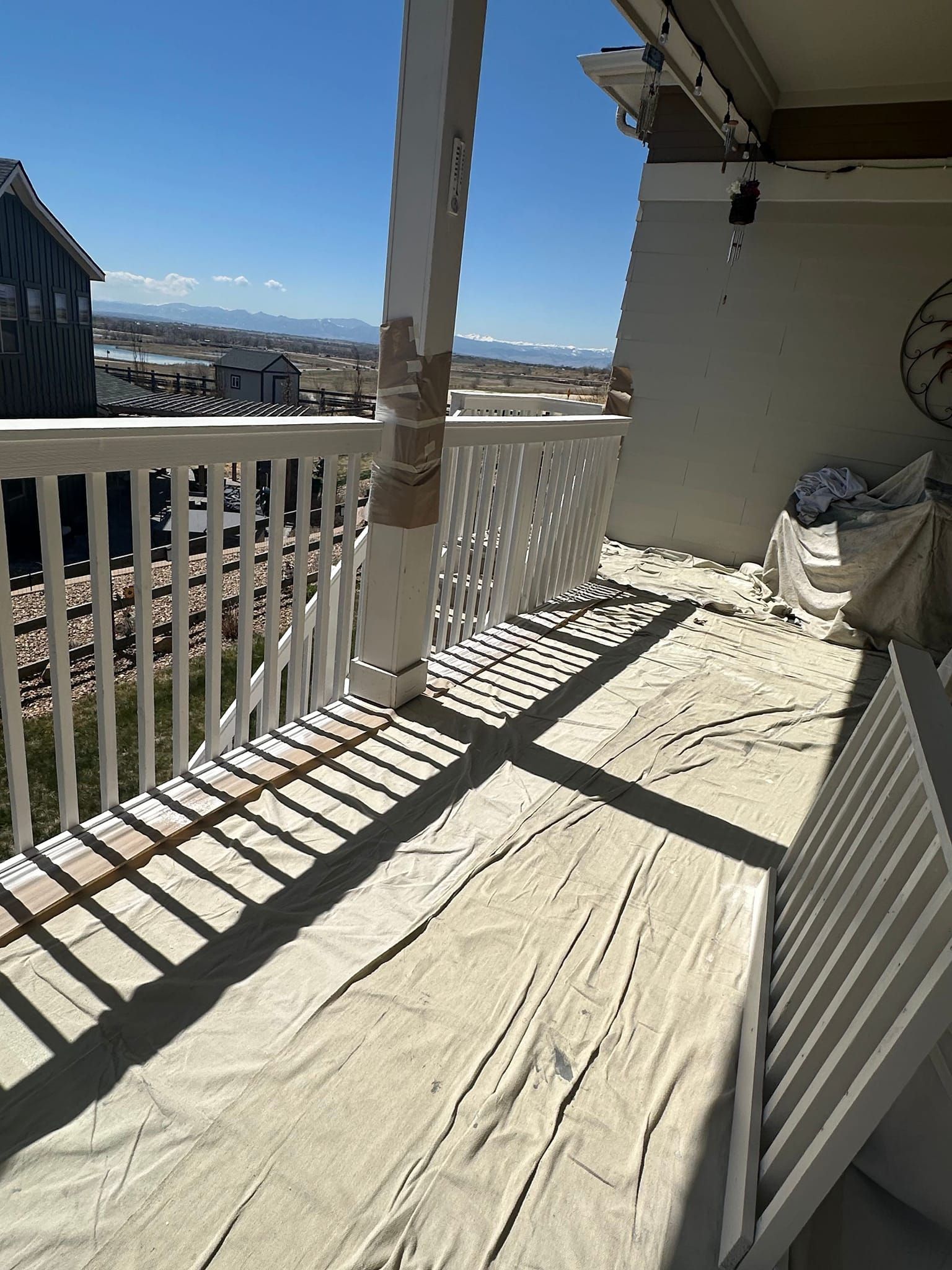 A balcony with a table and chairs and a clock on the wall.