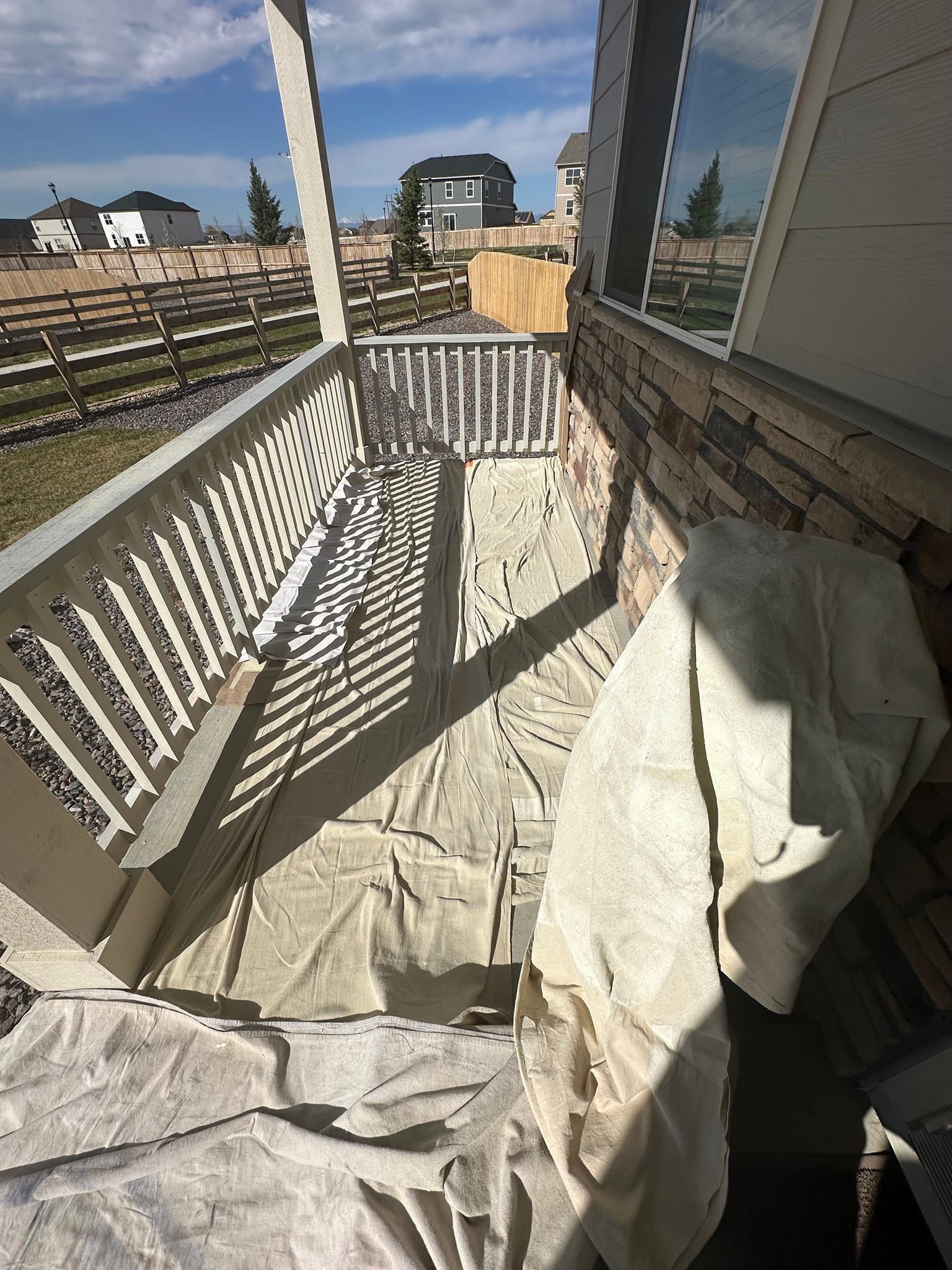 A balcony with a white tarp on it is being painted.
