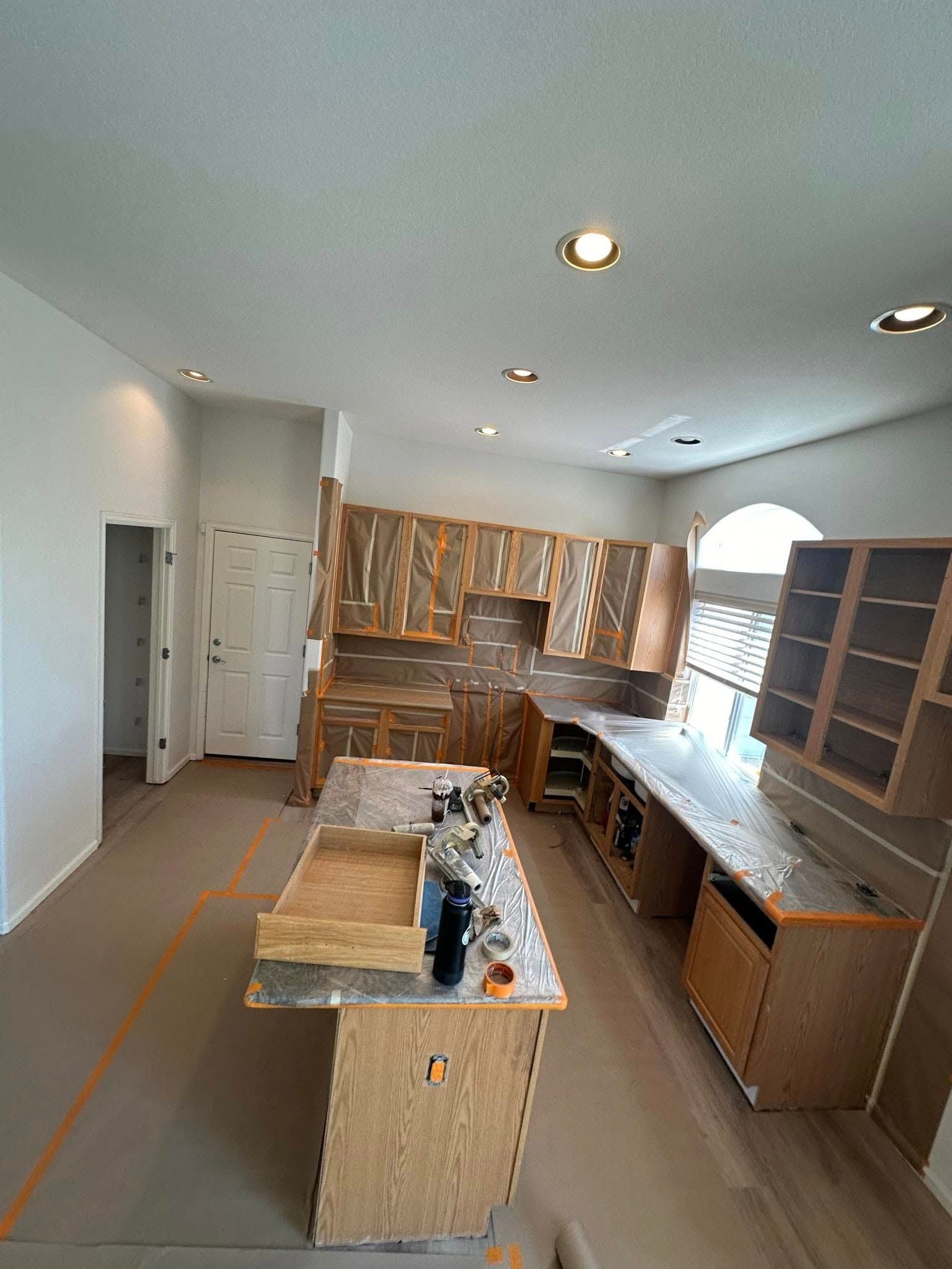 A kitchen is being remodeled with wooden cabinets and granite counter tops.
