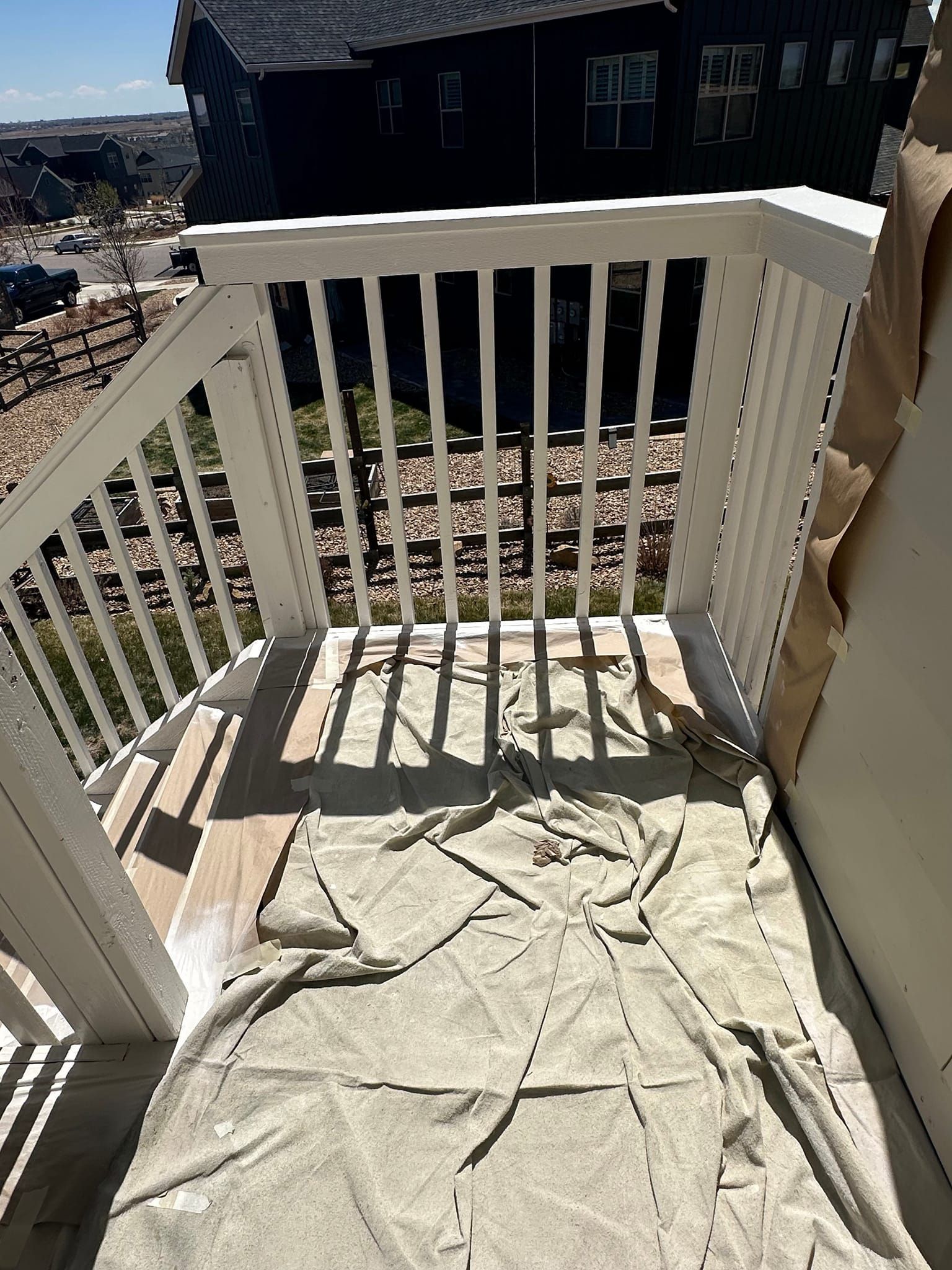 A balcony with a white railing and a blanket on it.