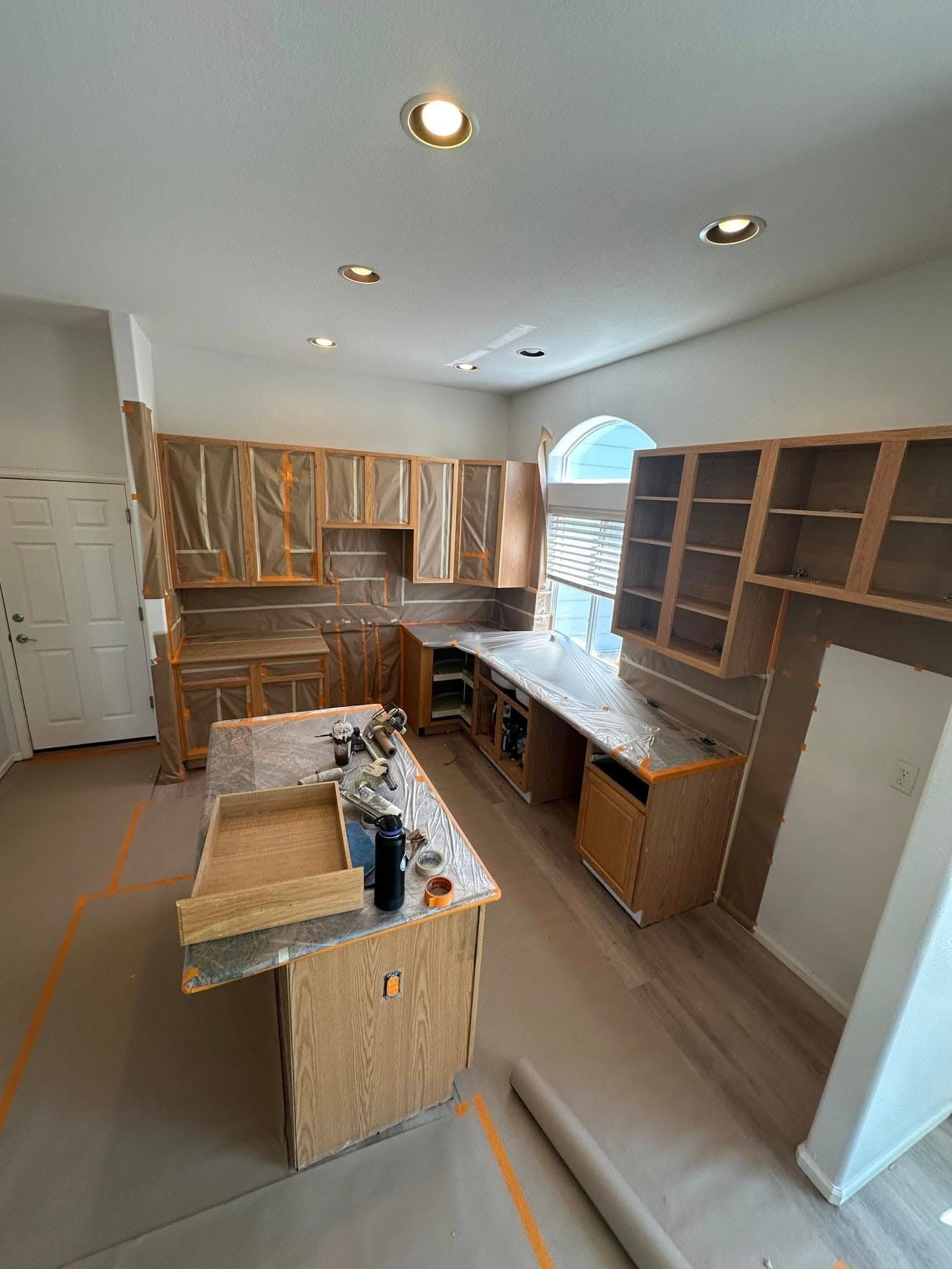 A kitchen under construction with wooden cabinets and marble counter tops.