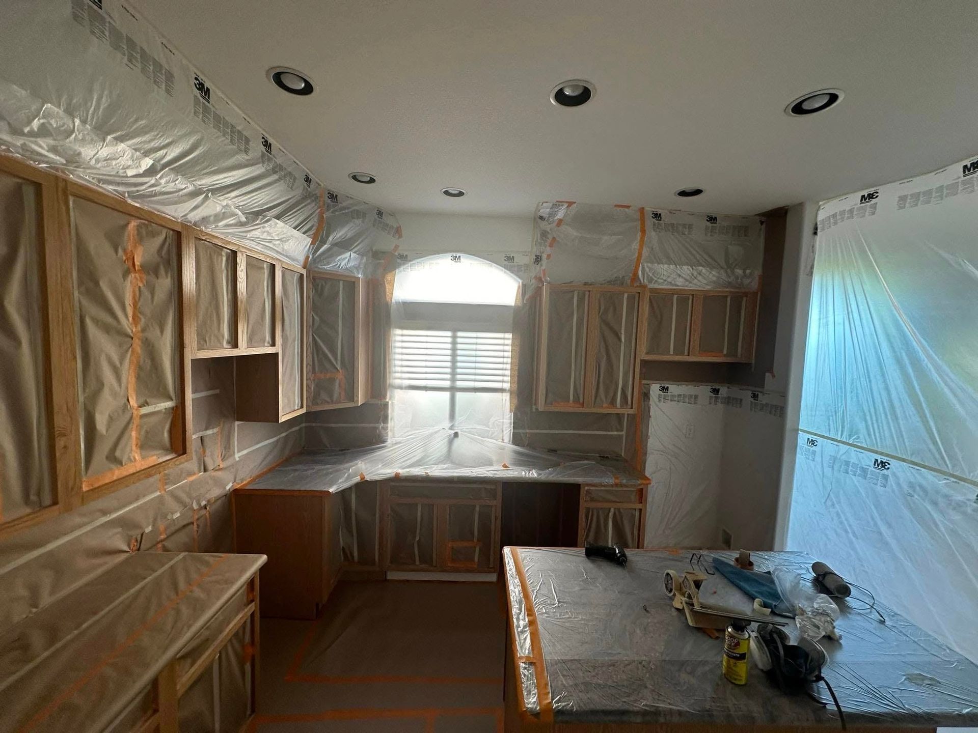 A kitchen is being remodeled and covered in plastic.