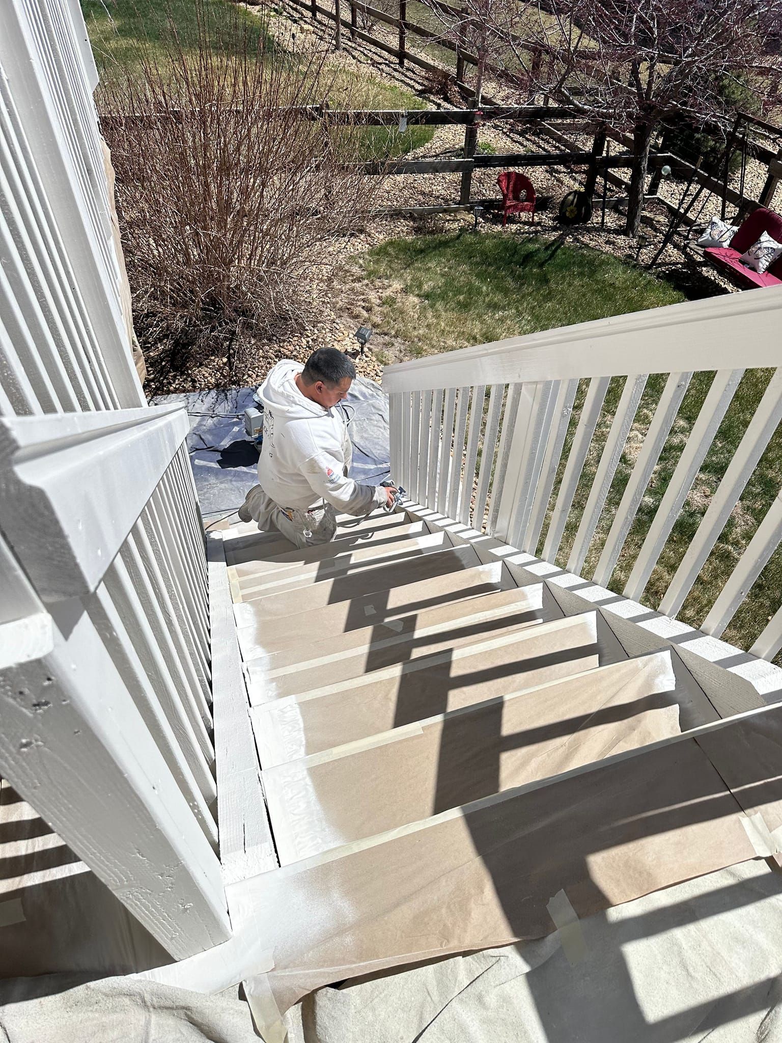 A man is painting the stairs of a house.