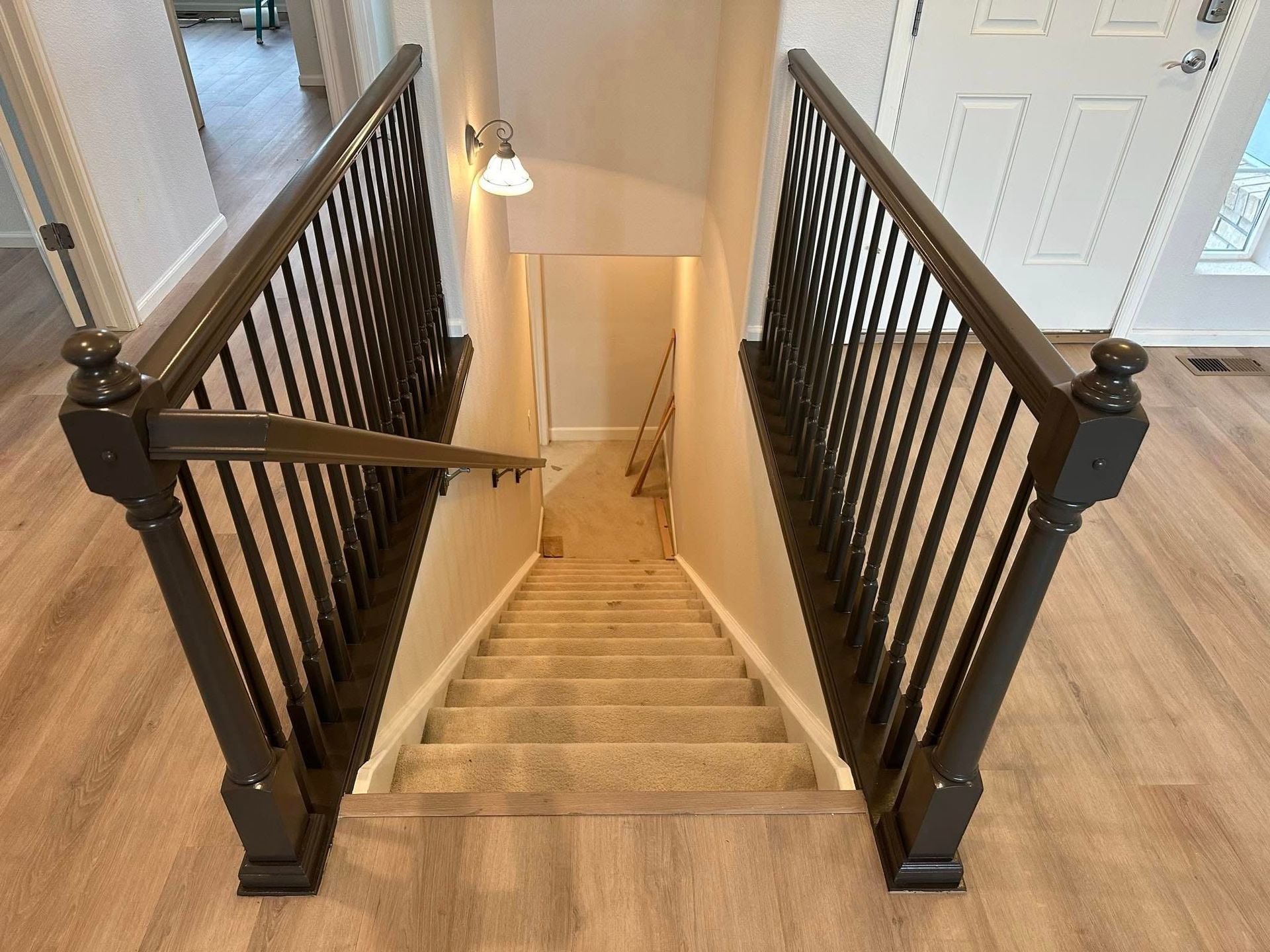 A set of stairs leading up to a basement with a black railing.