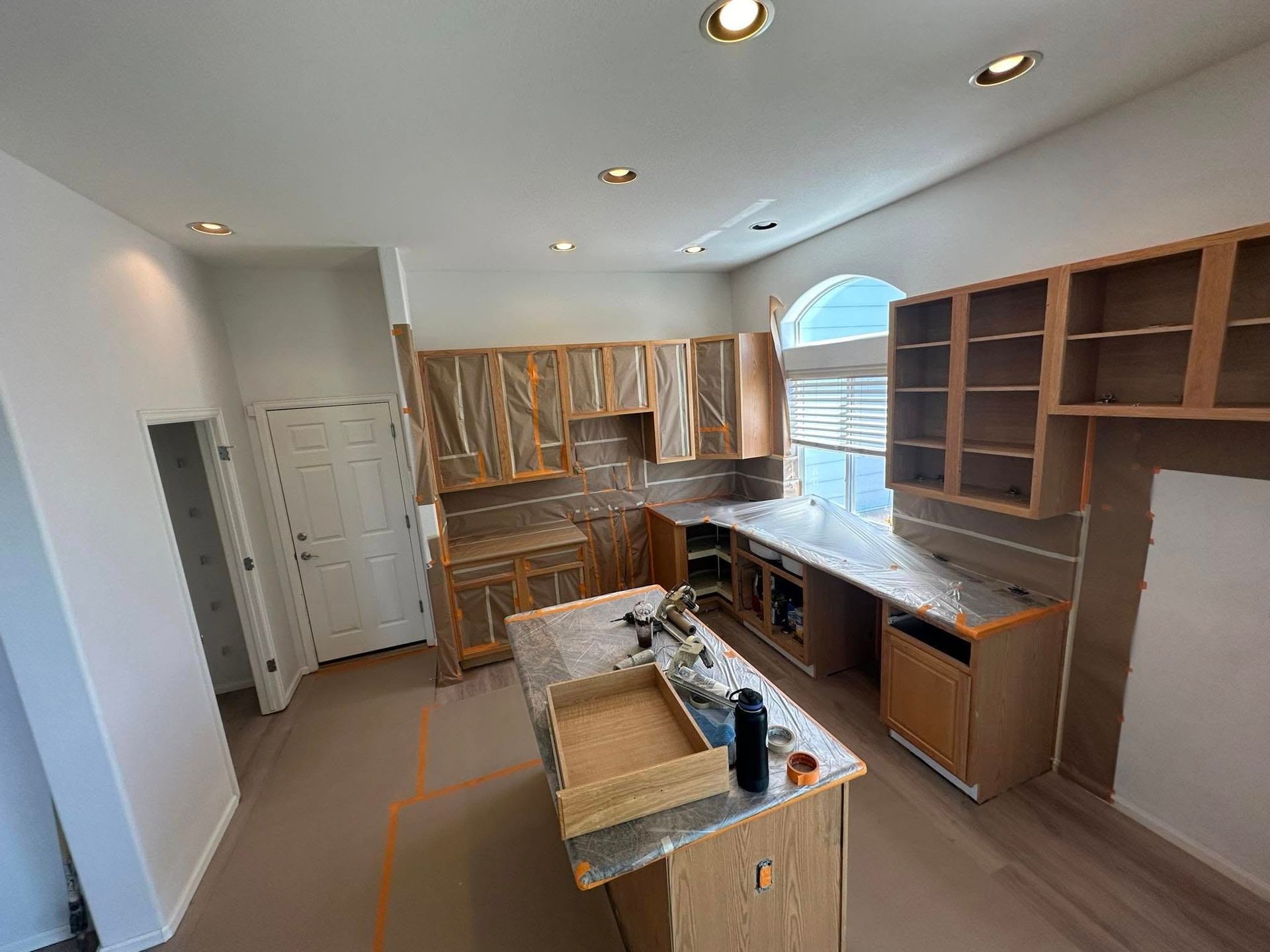 A kitchen with wooden cabinets and granite counter tops is being remodeled.