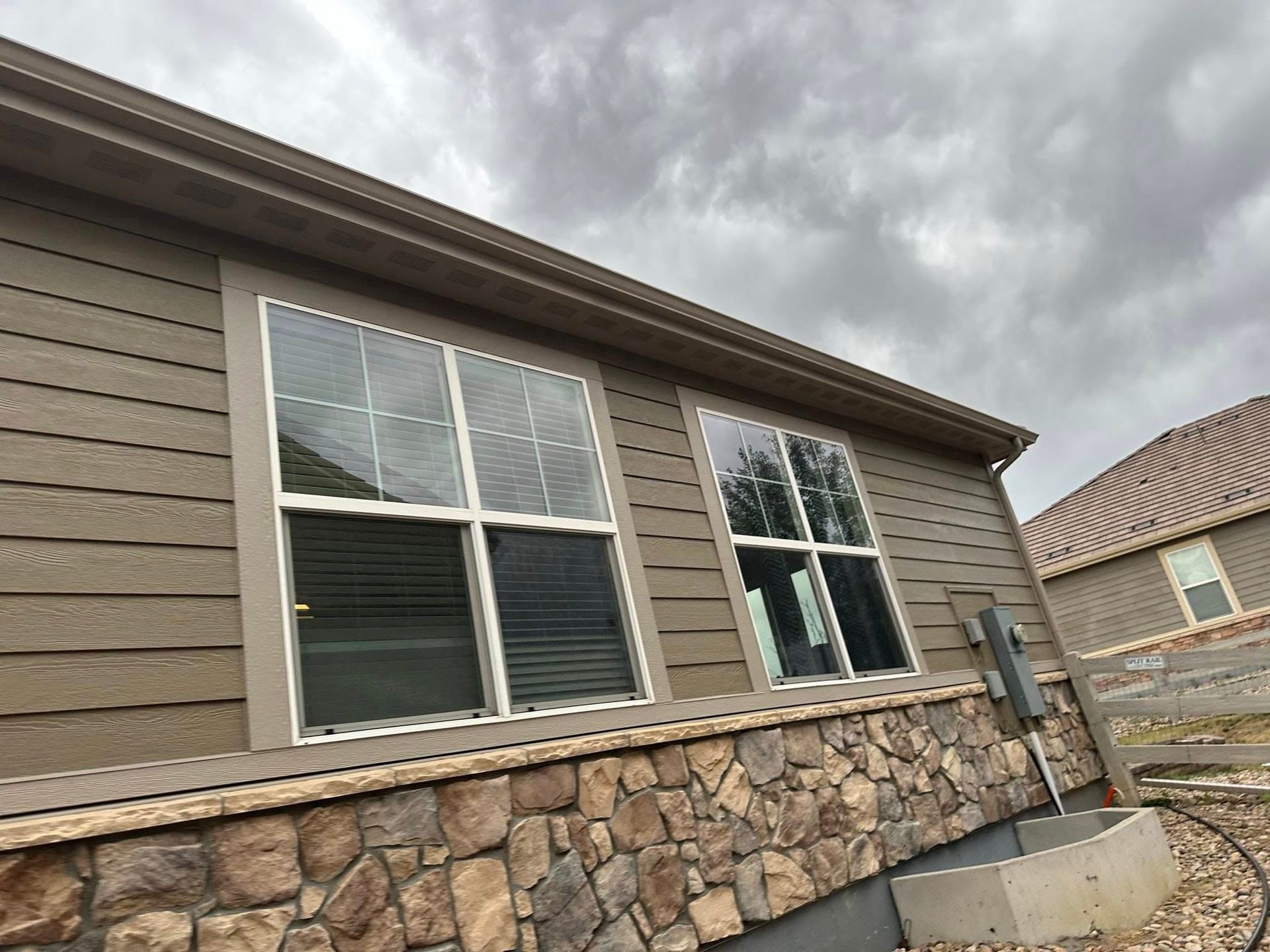 A house with a lot of windows and a stone wall.