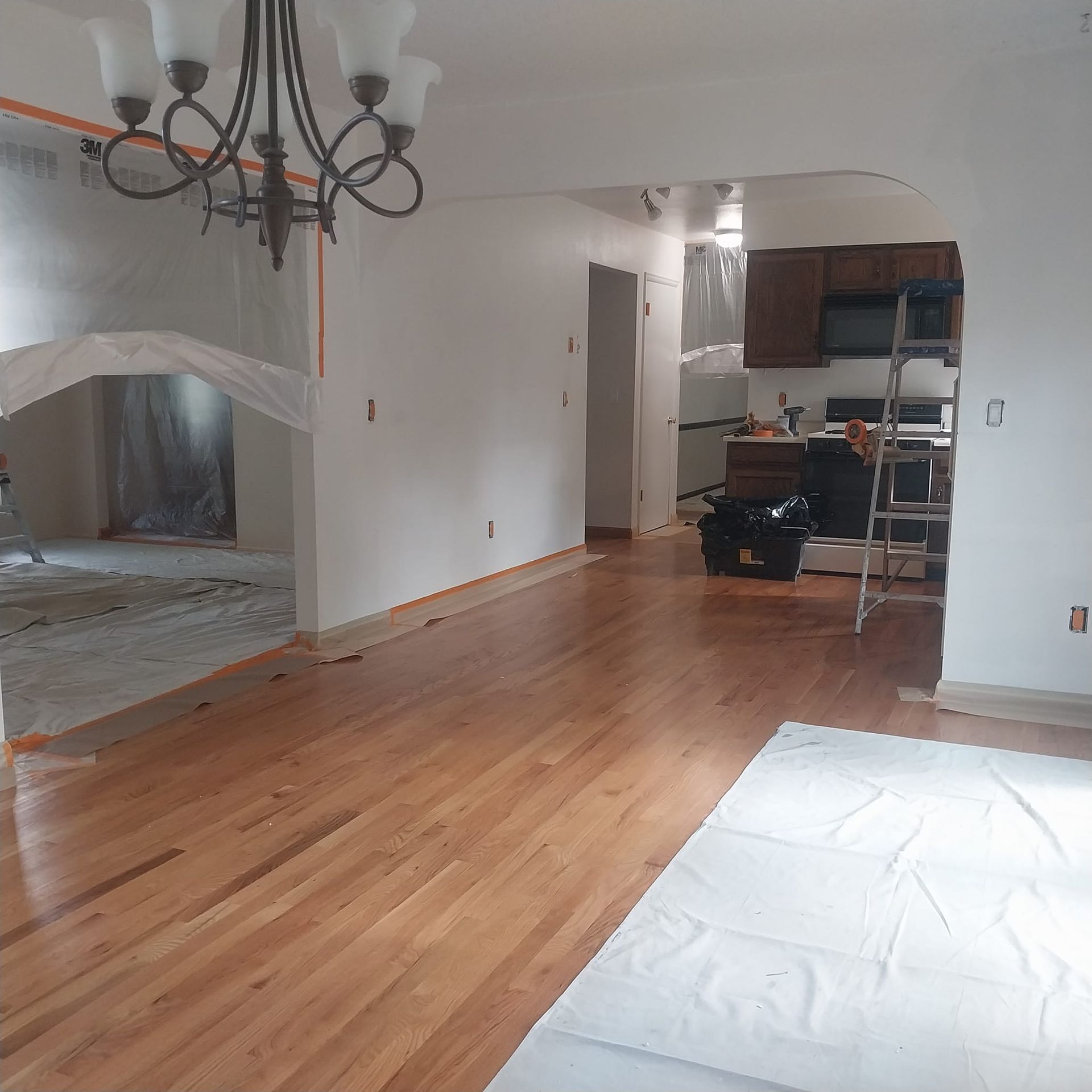 A living room with hardwood floors and a chandelier
