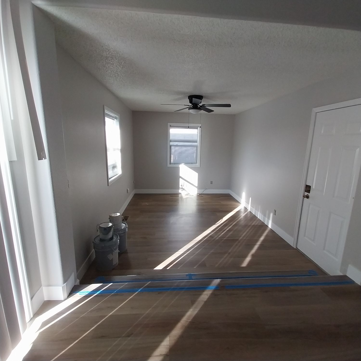 A living room with hardwood floors and a ceiling fan