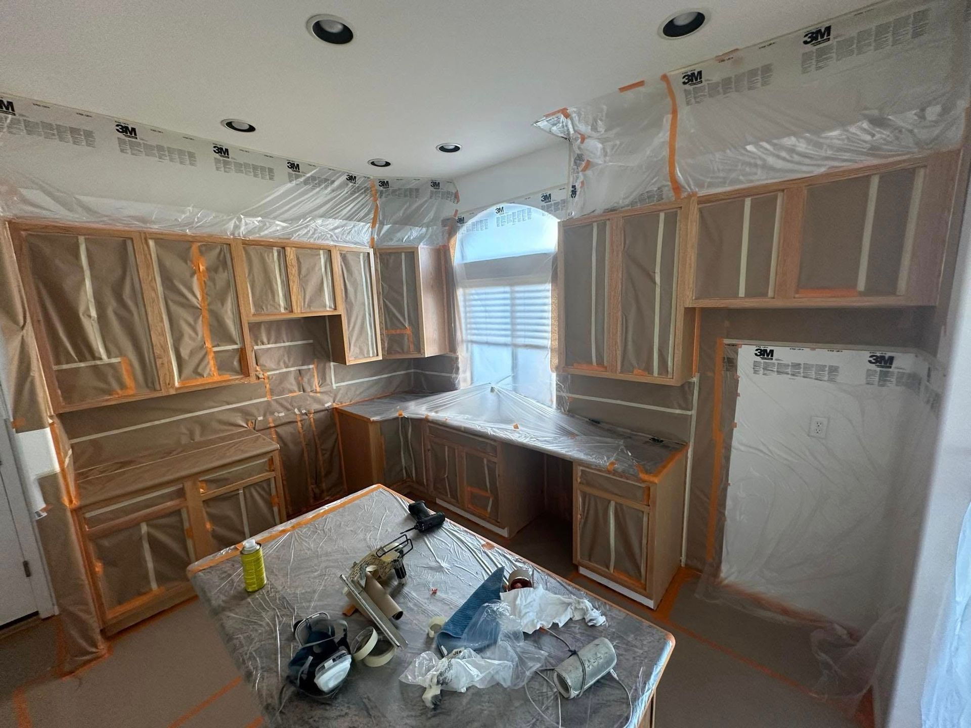A kitchen is being remodeled and is covered in plastic.