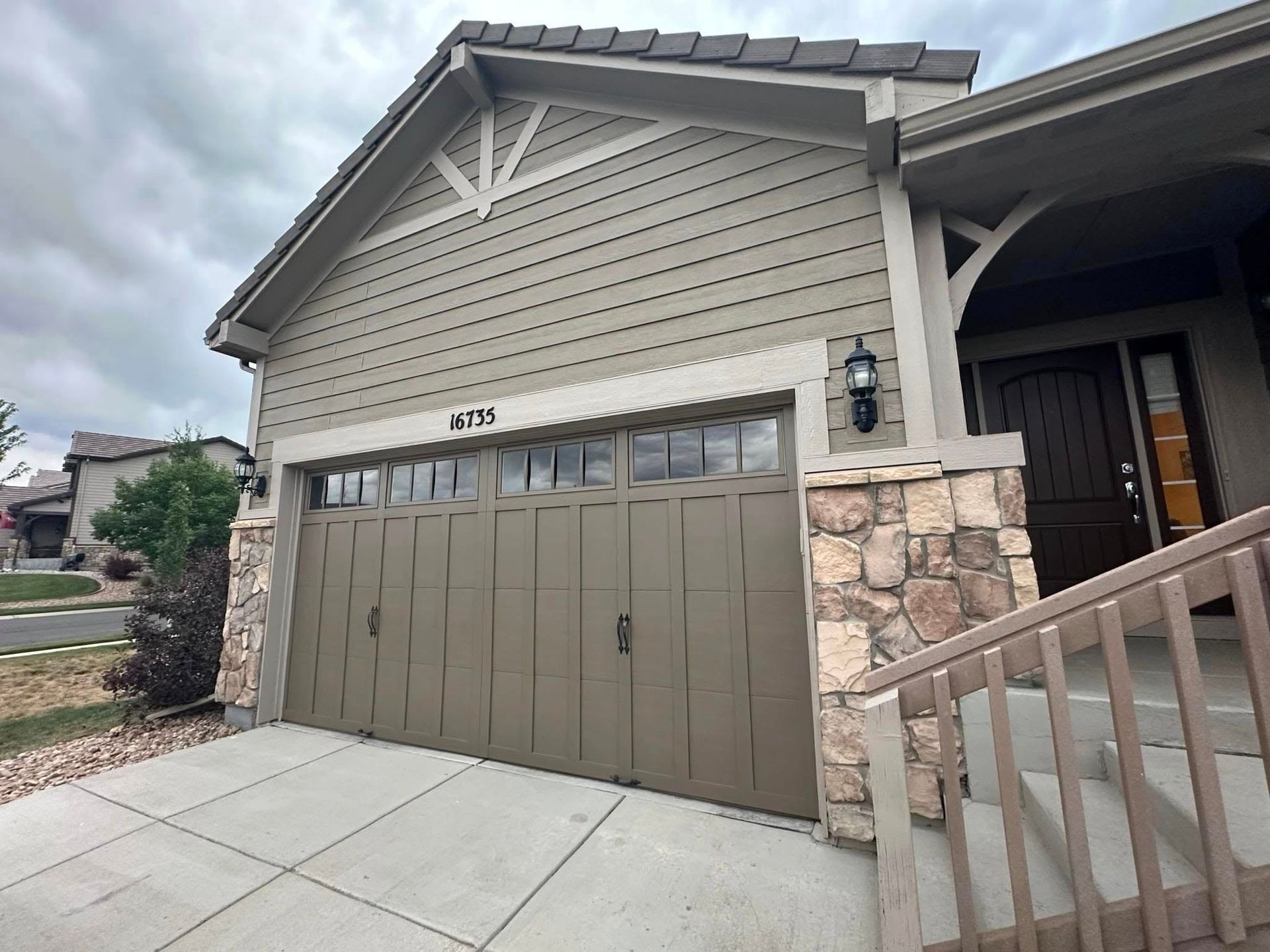 A house with a large garage door and stairs leading up to it.