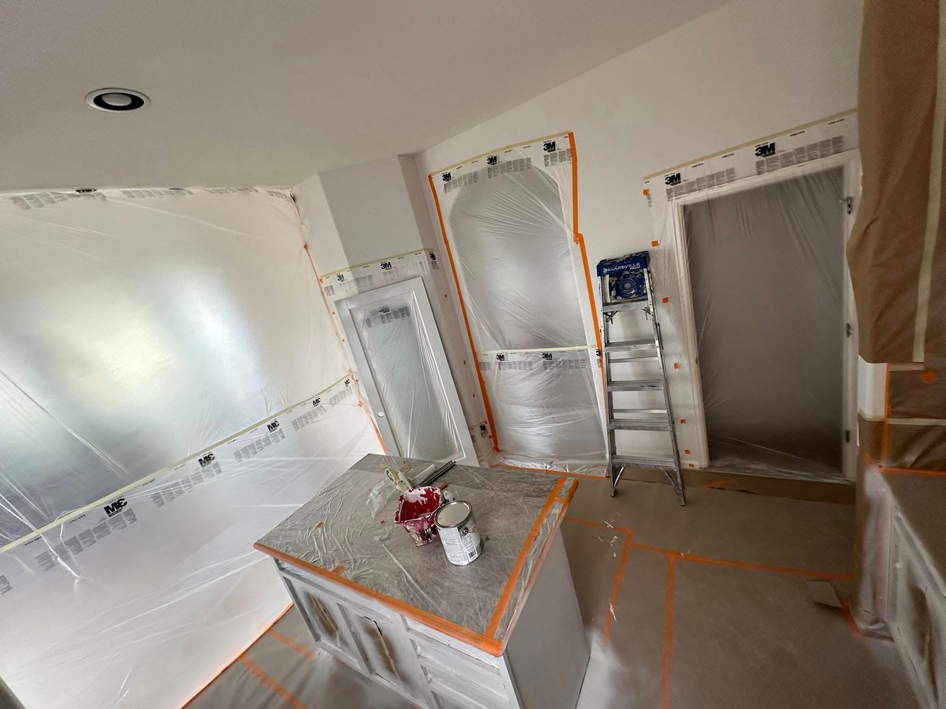 A room that is being painted with a ladder in it.