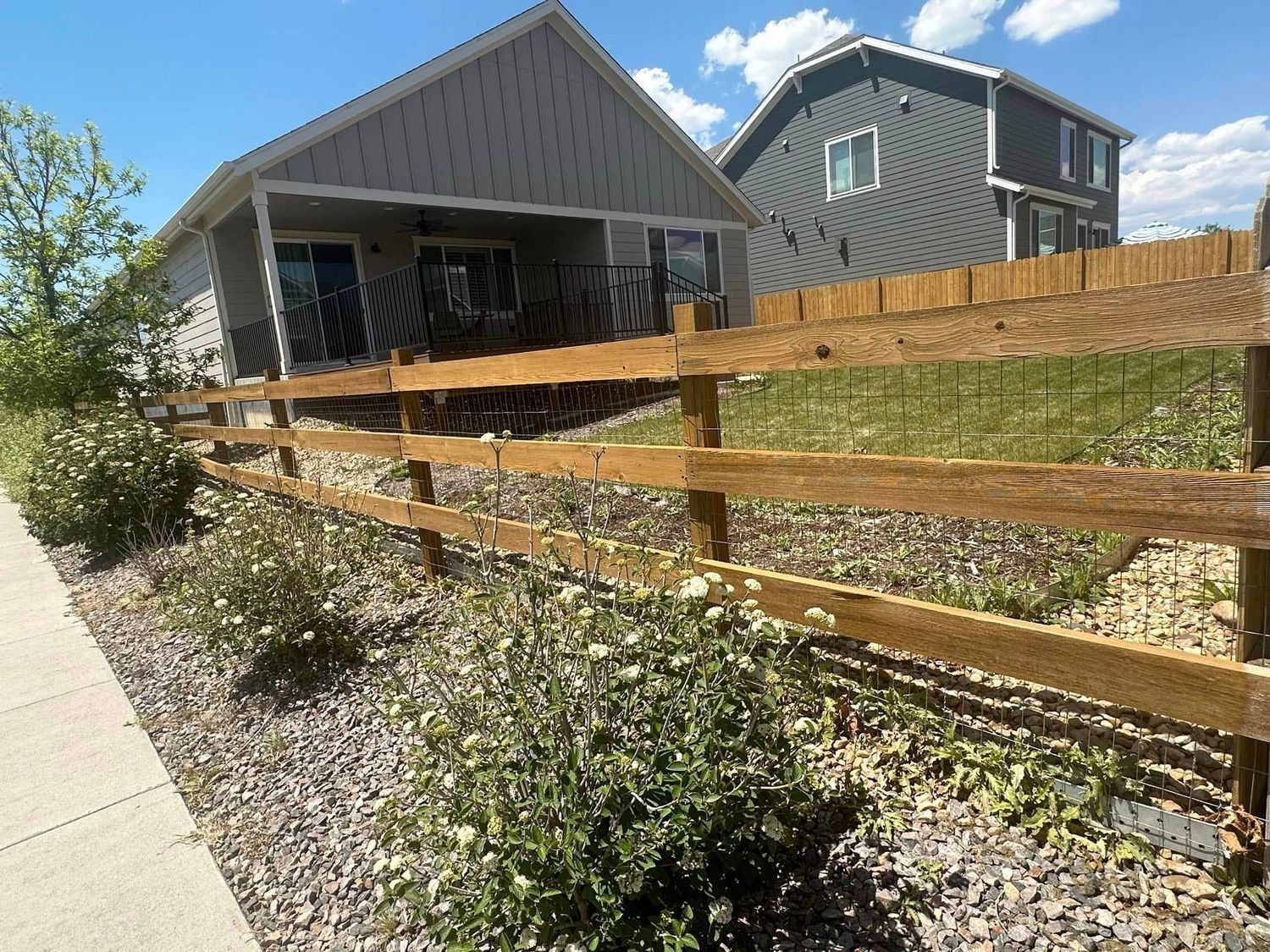 A house with a wooden fence in front of it.